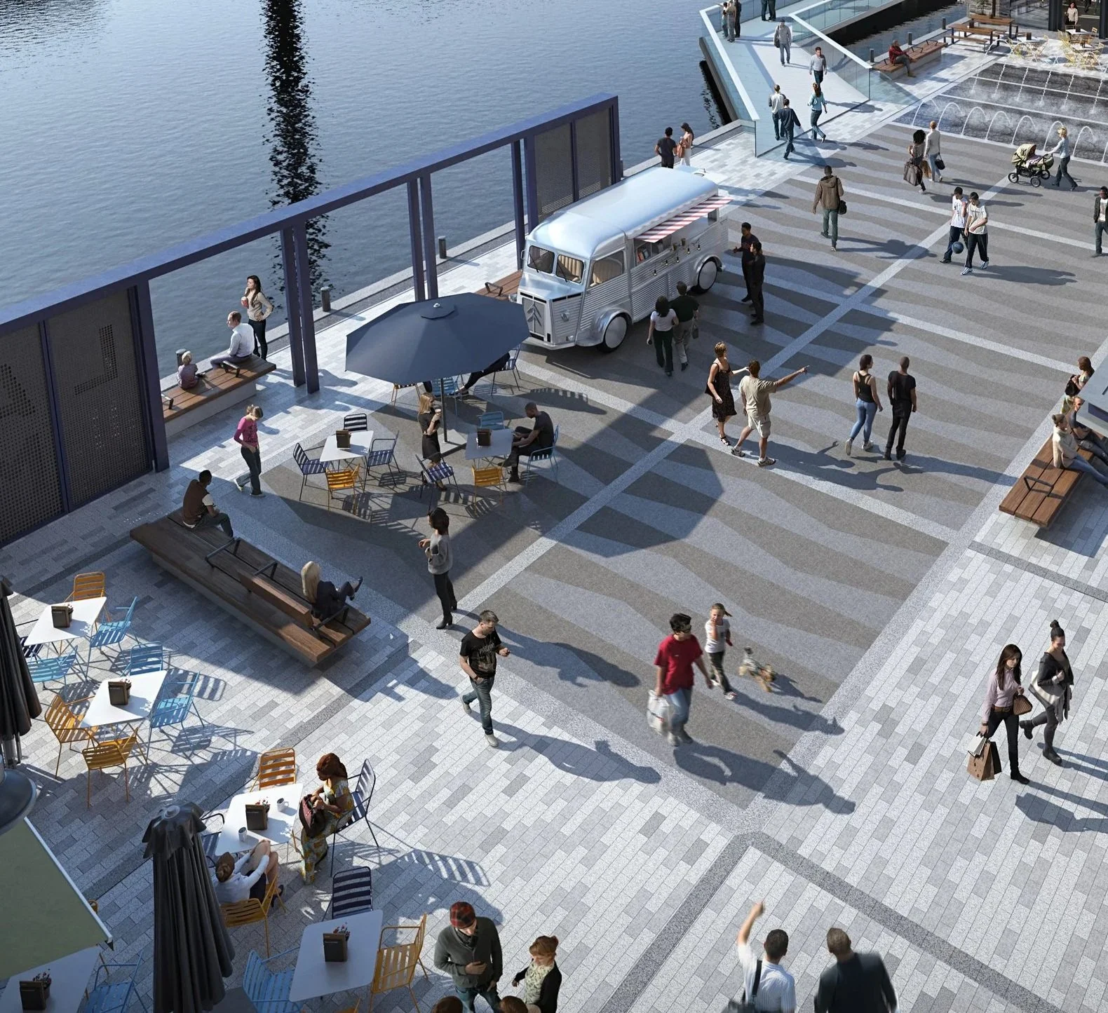 An outdoor urban waterfront area with people walking and sitting at tables, a food truck, benches, and a pier with water on the side.