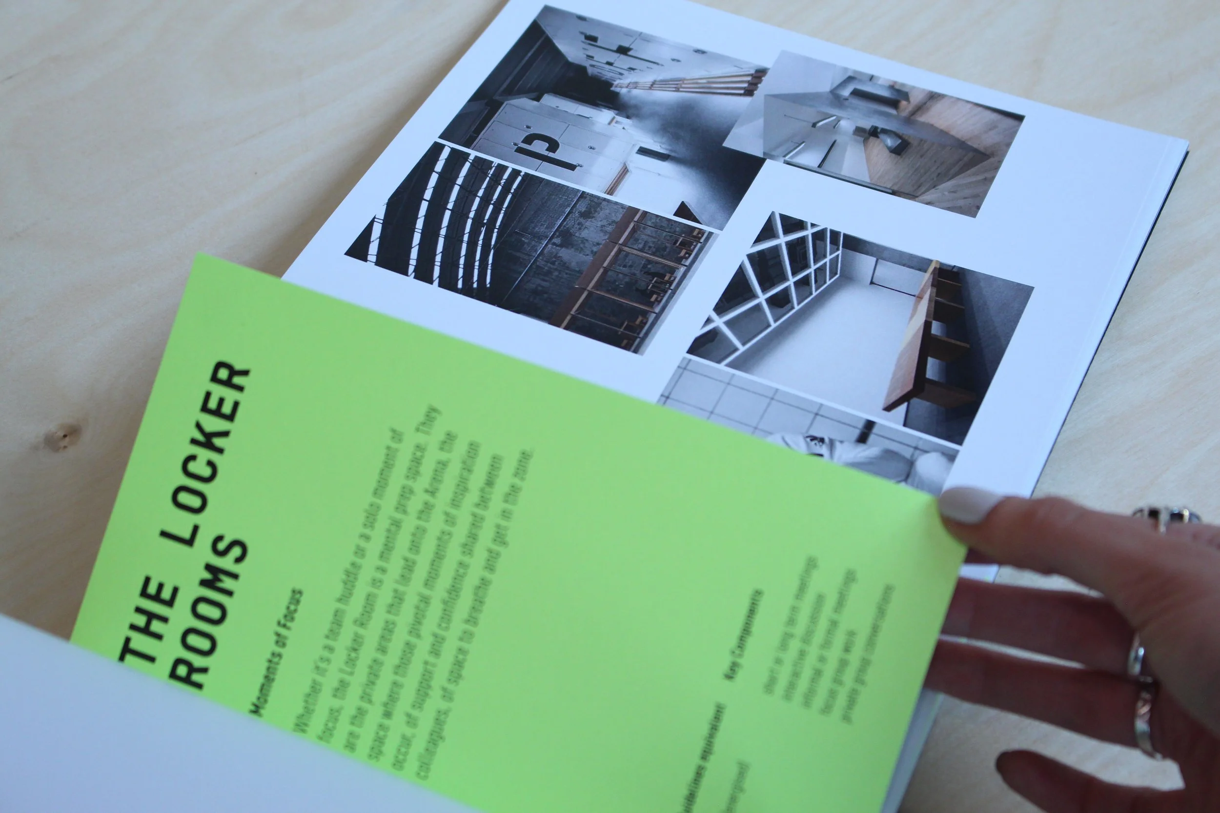A person's hand holding an informational flyer with yellow highlights, and a printed webpage with images of modern interior design spaces on top.