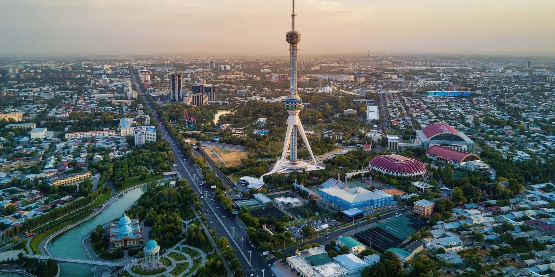 Aerial view of Kuala Lumpur city showing the Kuala Lumpur Tower (Menara Kuala Lumpur) surrounded by cityscape, residential areas, parks, and buildings.