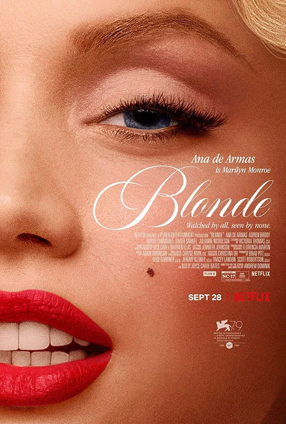 Close-up of a woman's face with red lipstick, showcasing her eye with well-defined eyebrows and eyelashes, and a small mole above her lip, on a promotional poster for the Netflix film 'Blonde' starring Ana de Armas.
