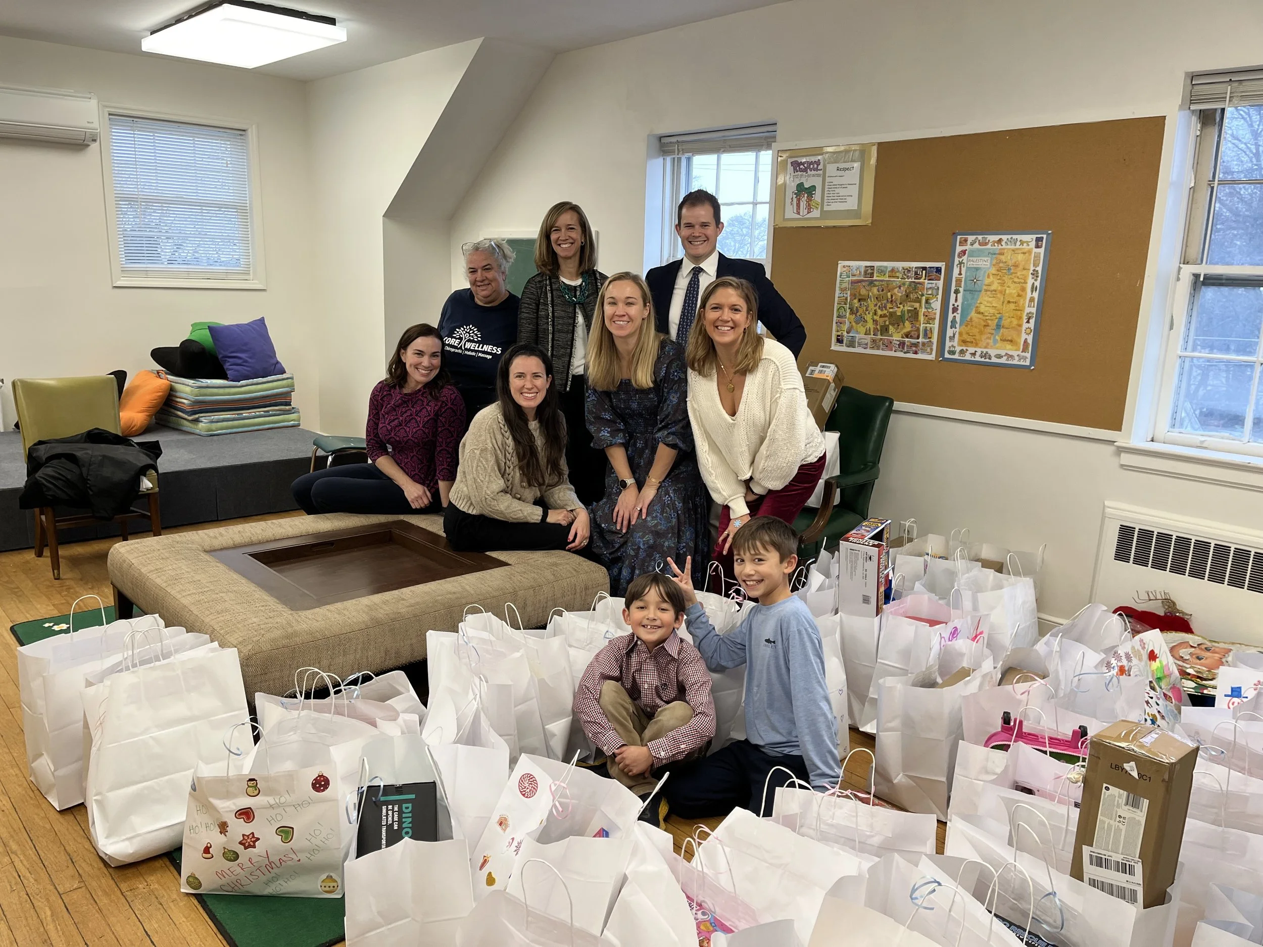 Group of seven people who have just completed assembling gift bags of Christmas toys for Mission partners