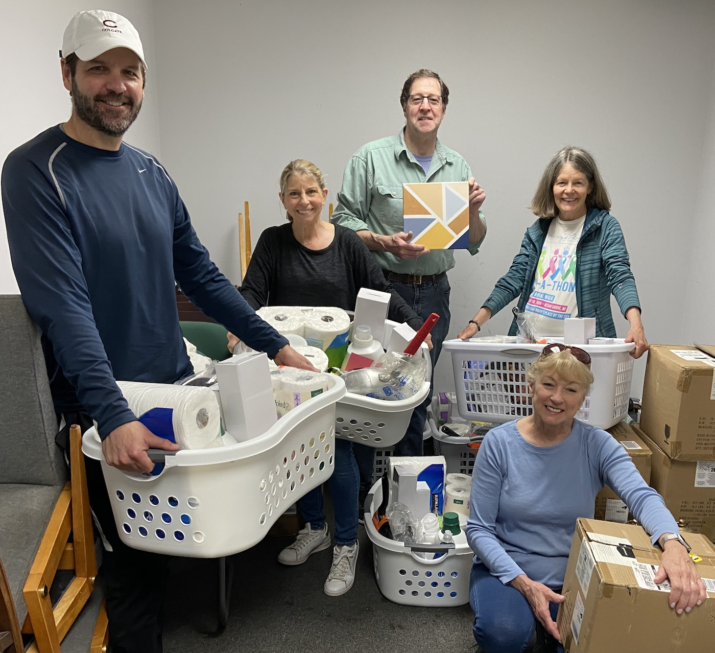 People holding laundry baskets full of supplies for The Warehouse NJ to give to the newly housed