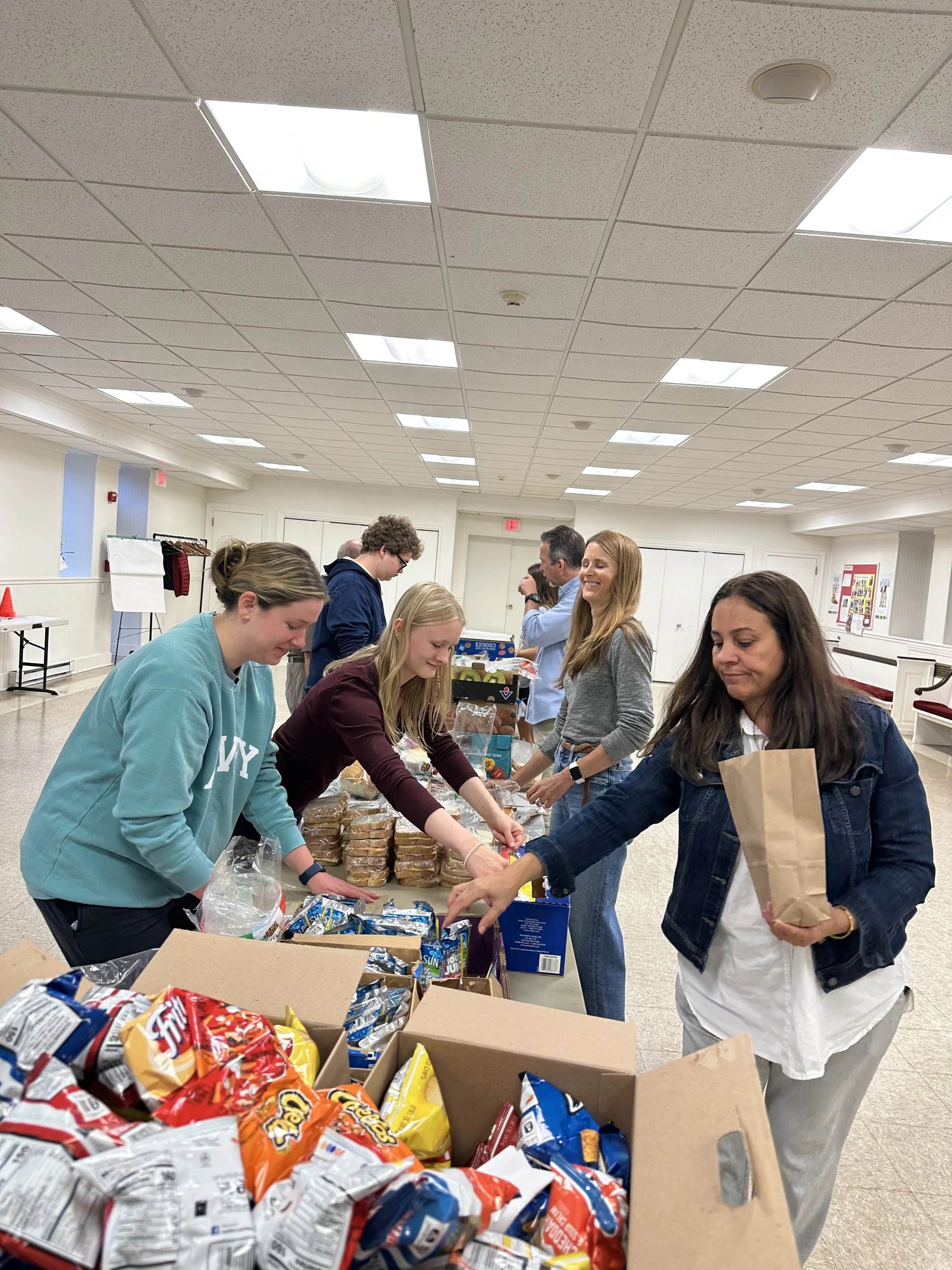 People preparing bag lunches for House of Mercy Mission