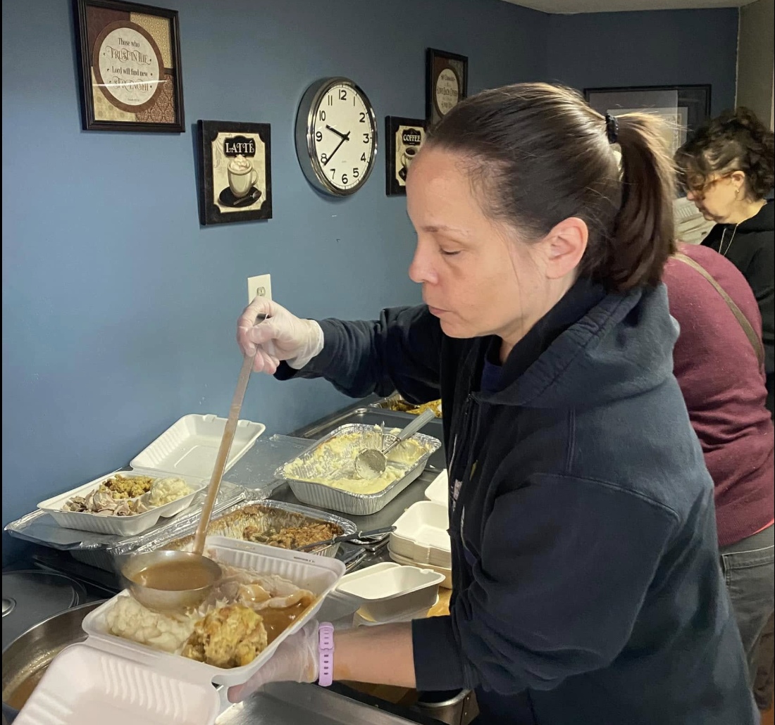 A woman serving food at the House of Merch Mission Thanksgiving dinner prepared by Wyoming Church
