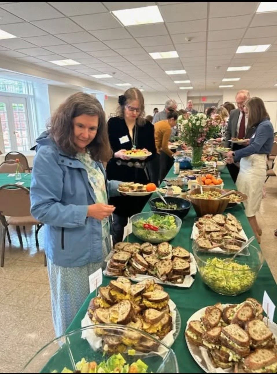 Church members serving themselves food at a church brunch in Fellowship Hall.