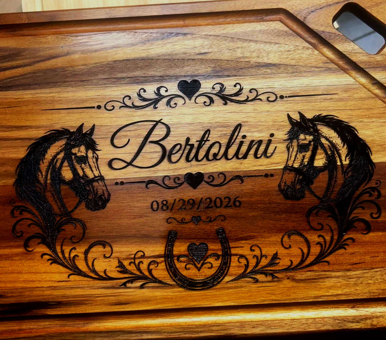 A decorative wooden plaque with the name 'Bertolini', two horse illustrations, the date 08/29/2026, and hearts, flowers, and horseshoe motifs.