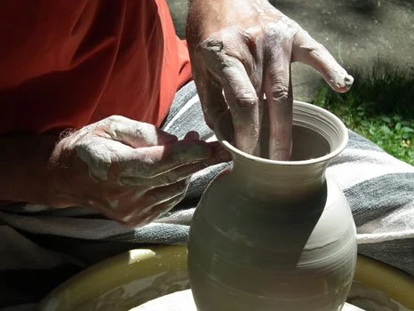Jason refines the edge of a pot.