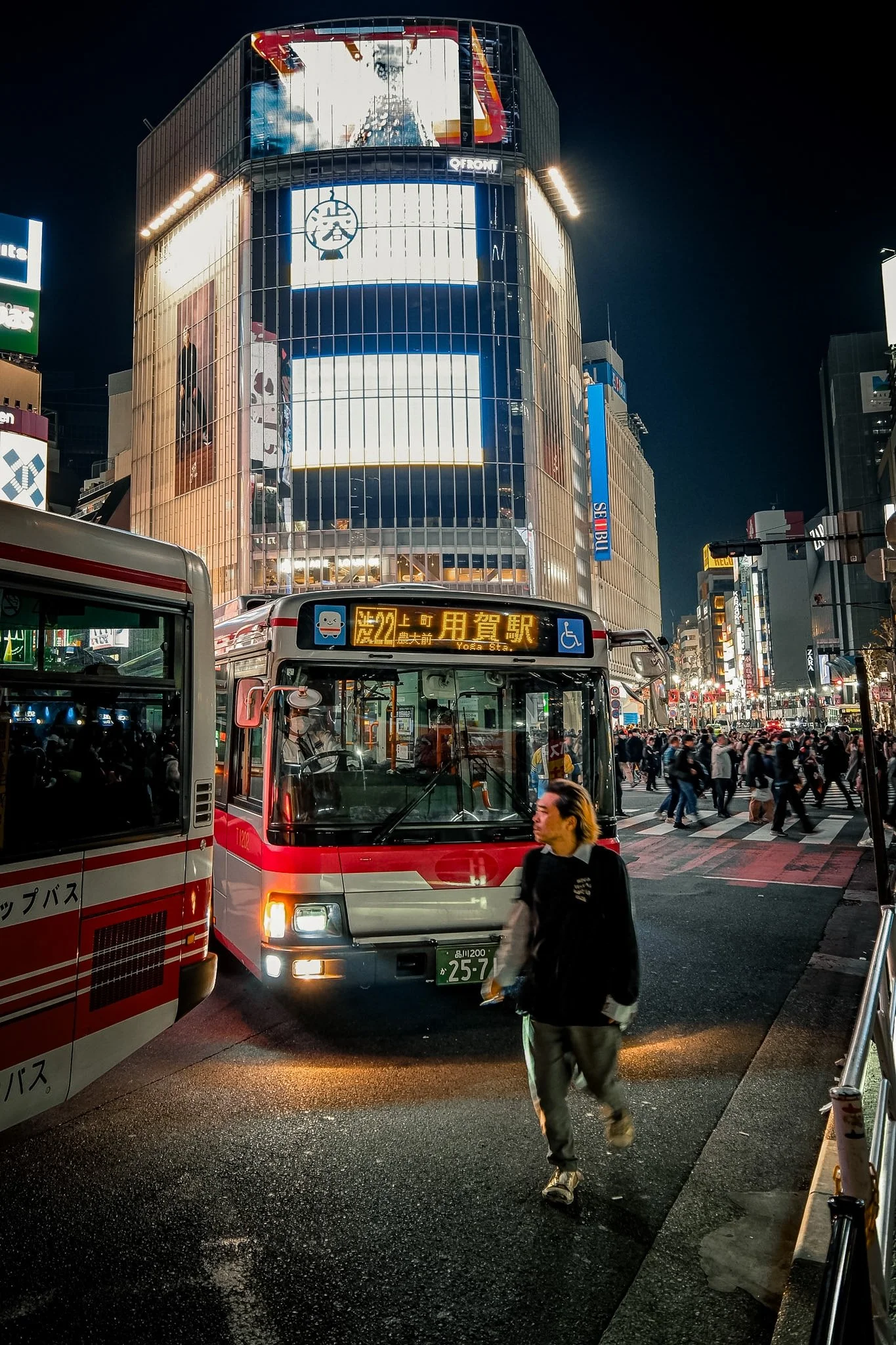 Man walking in front of a bus at Shibuya Crossing, Shibuya Japan 