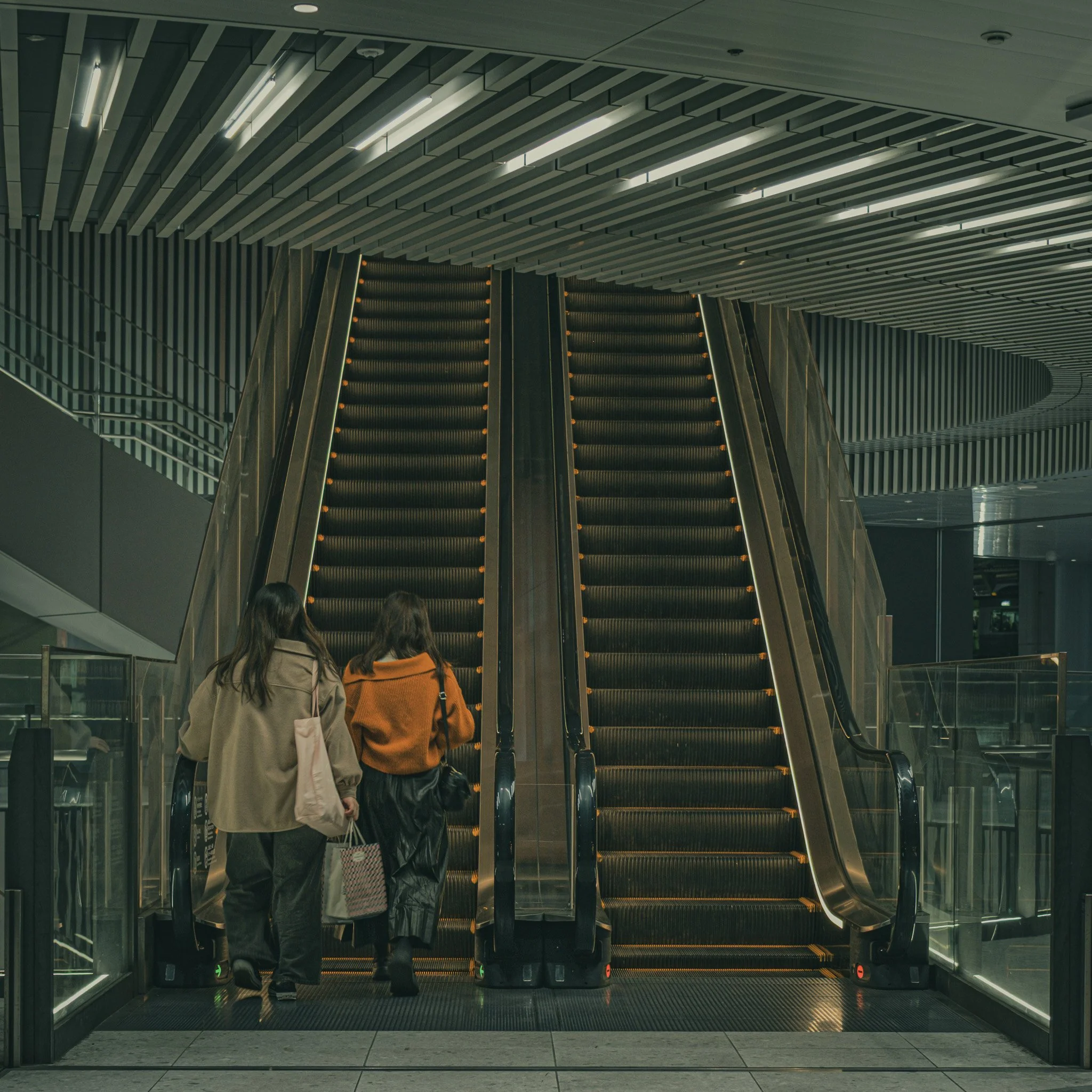 Two people taking the escalator in Tokyo Japan 