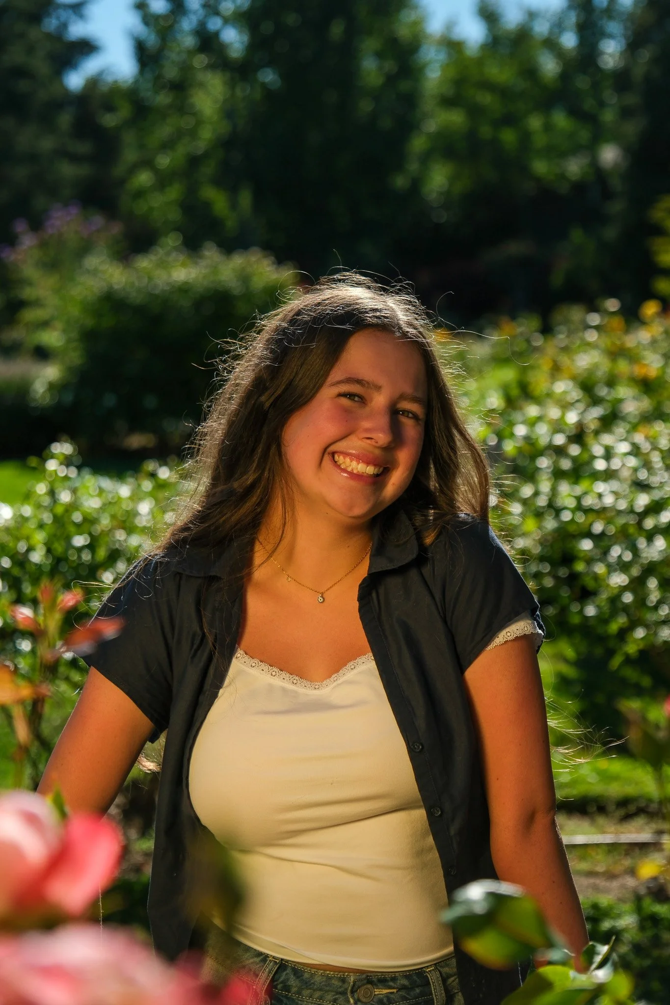 Girl with long hair in a garden taking a Senior Portrait, Woodland Park Rose Garden 