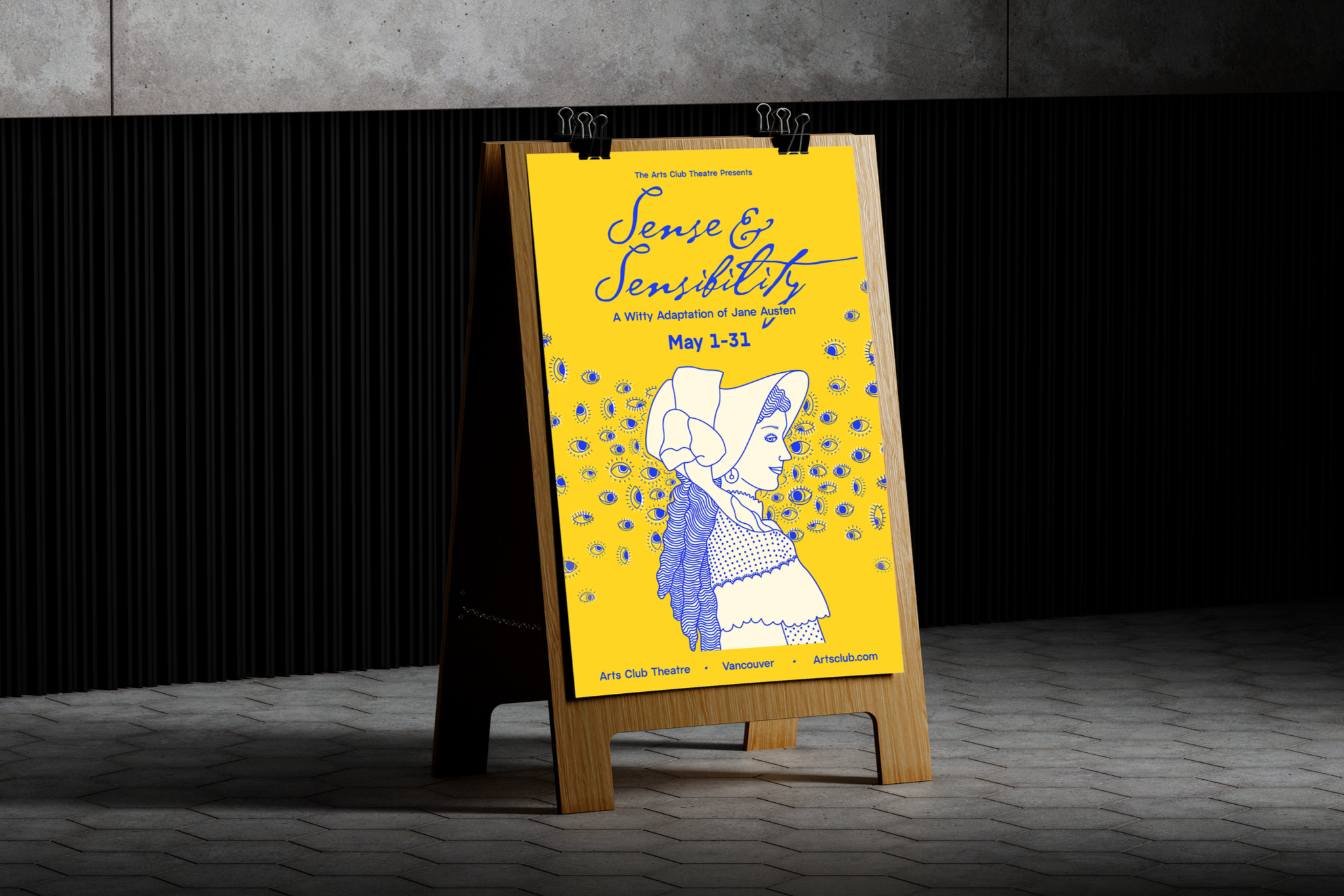 A yellow poster board on a wooden stand advertising a theatrical production of "Sense & Sensibility" by the Arts Club Theatre in Vancouver, scheduled for May 1-31, with an illustration of a woman surrounded by eyes.