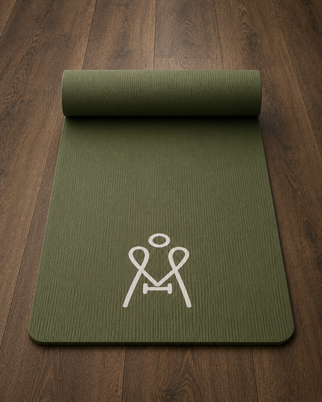 A green yoga mat with a white cartoon-style figure of a person in a stretching pose printed on it, placed on a wooden floor.