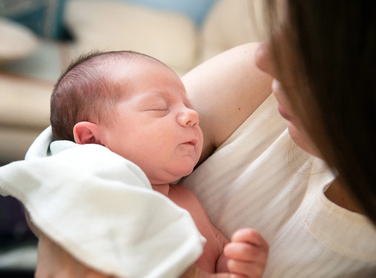 Neugeborenes schläft auf der Brust seiner Mutter