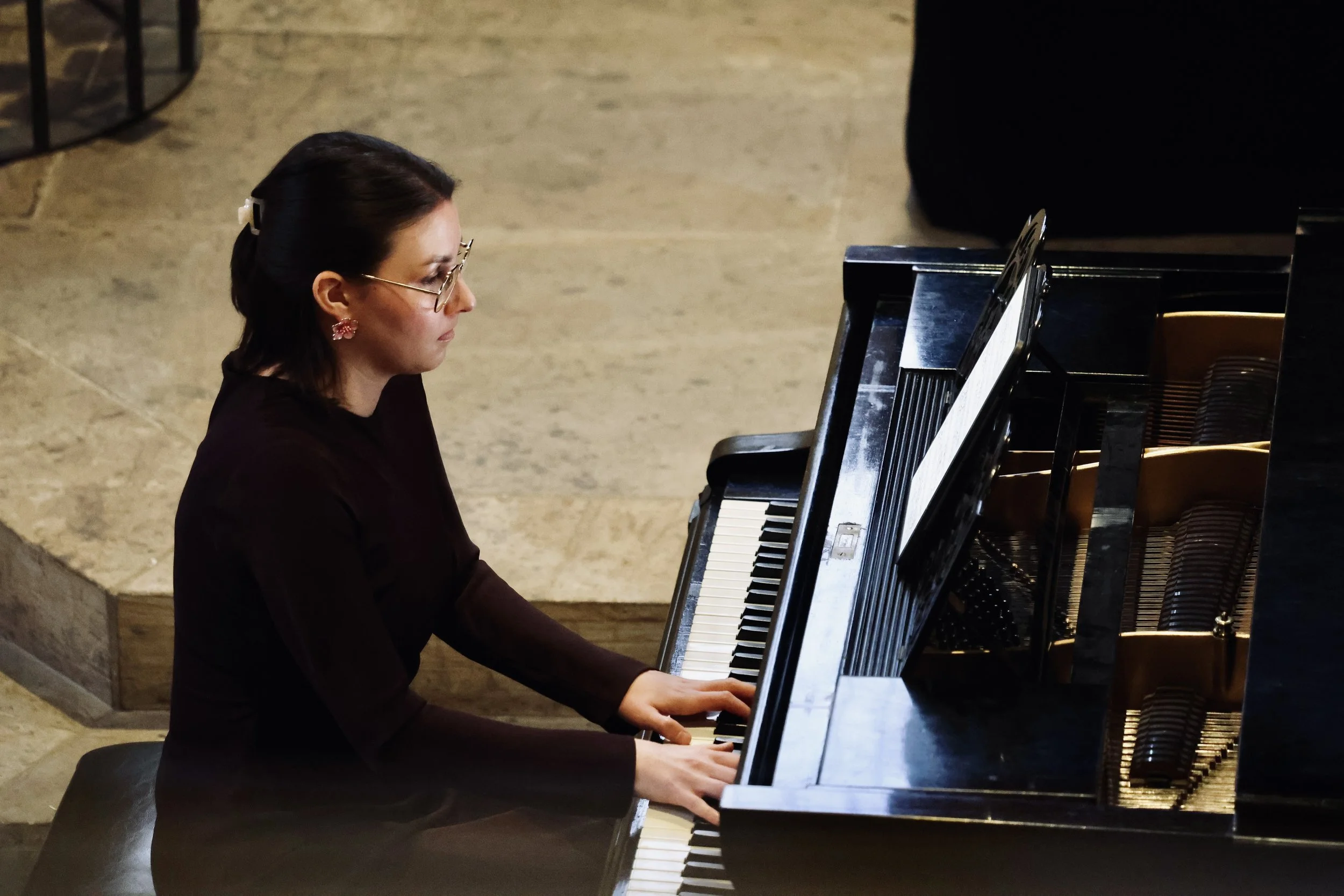 Frau spielt Klavier in einem Saal