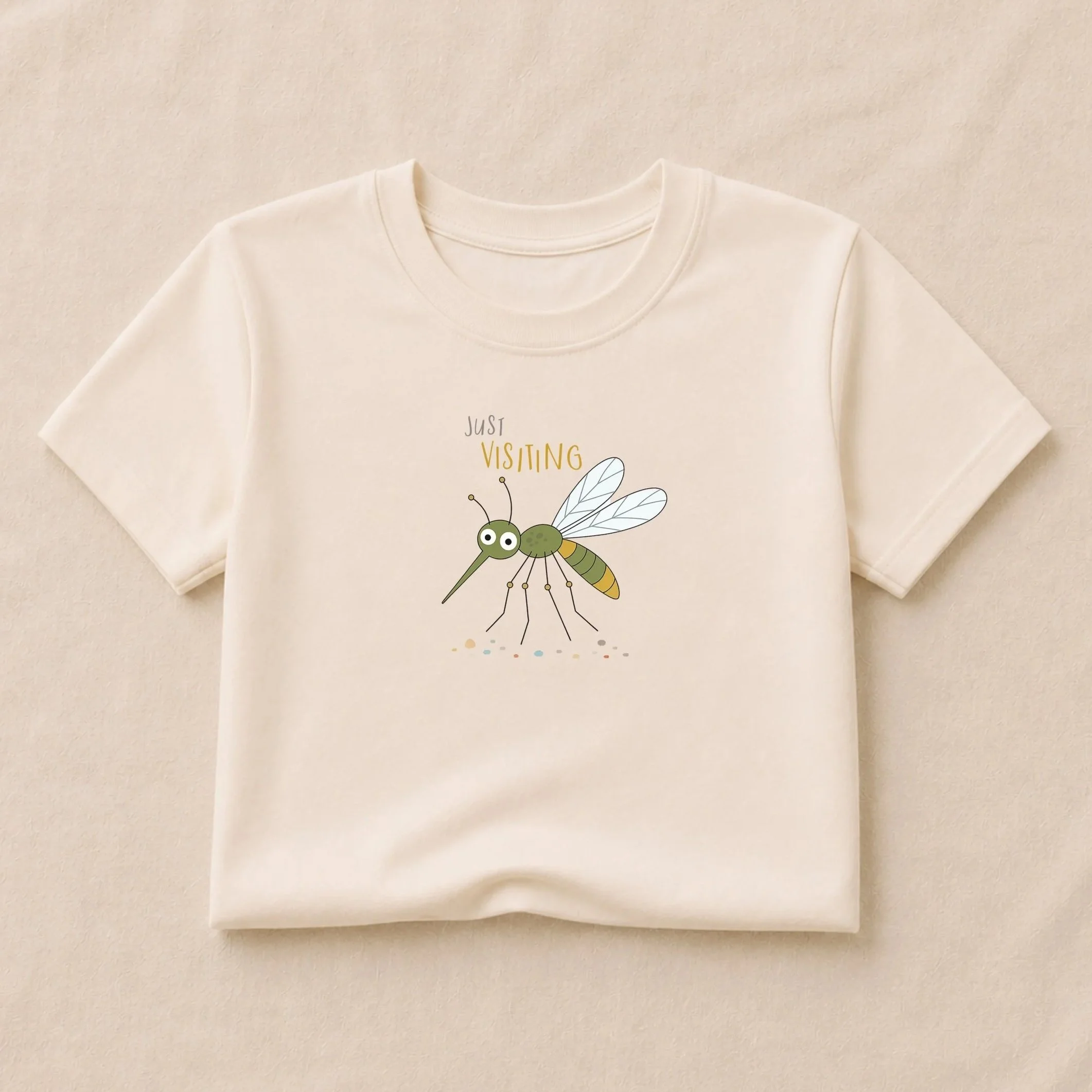 Cream kids T-shirt featuring Milton the mosquito with the words “Just Visiting,” from the Frank & Ollie illustration collection.