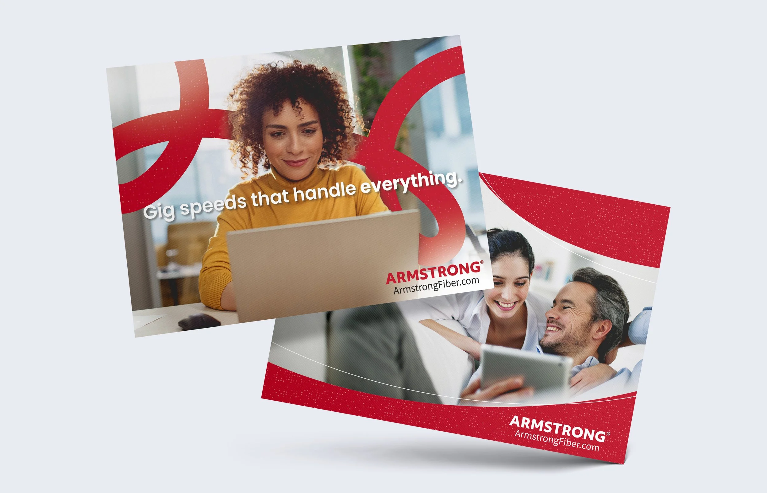 Close-up of a colorful Armstrong Fiber advertisement flyer featuring a woman with curly hair working on a laptop, smiling; background shows other people celebrating and smiling.