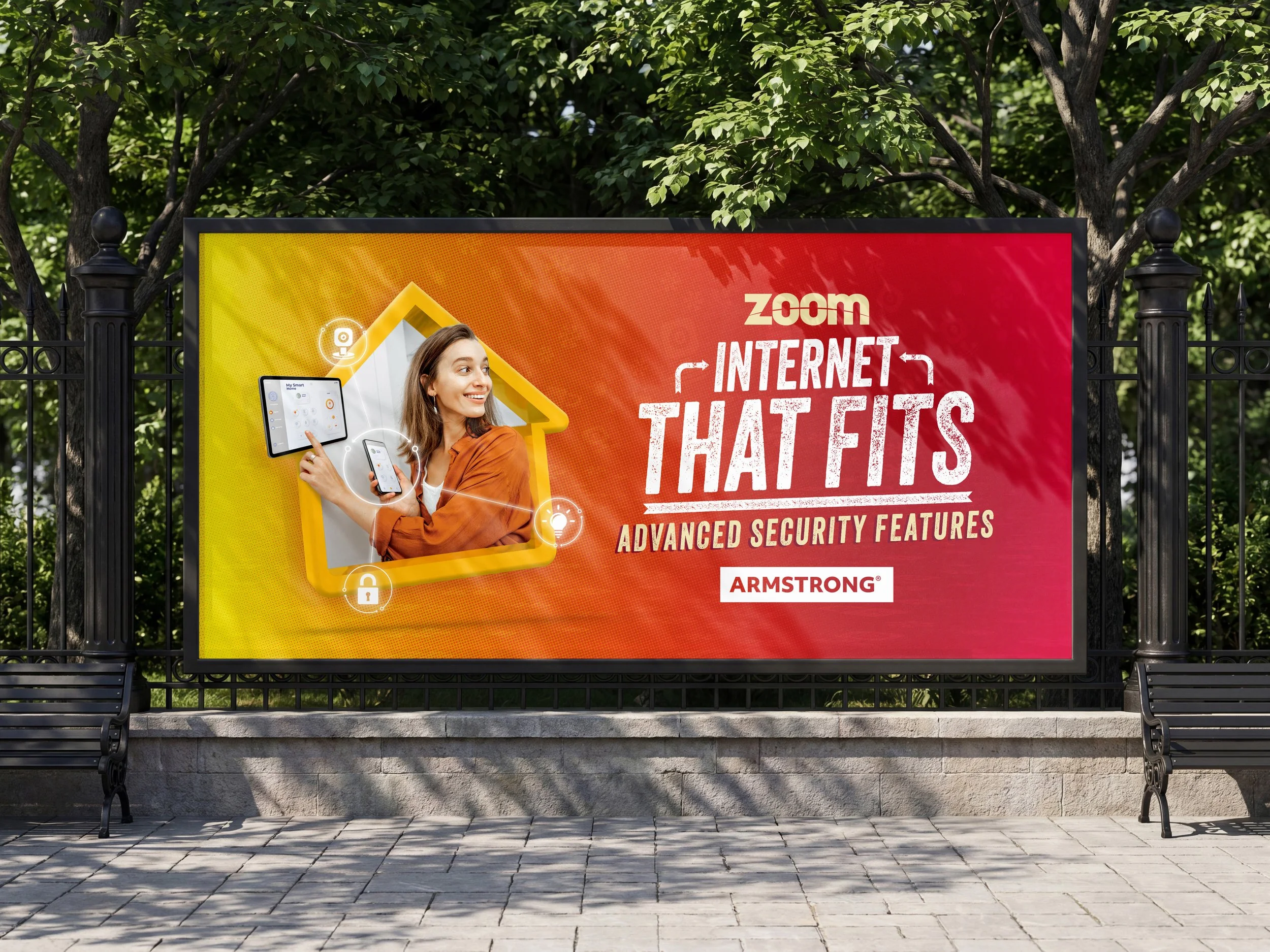 Billboard advertisement for Zoom Internet with a smiling woman holding a tablet and smartphone, highlighting advanced security features, mounted on a wall in an outdoor park area with trees in the background.