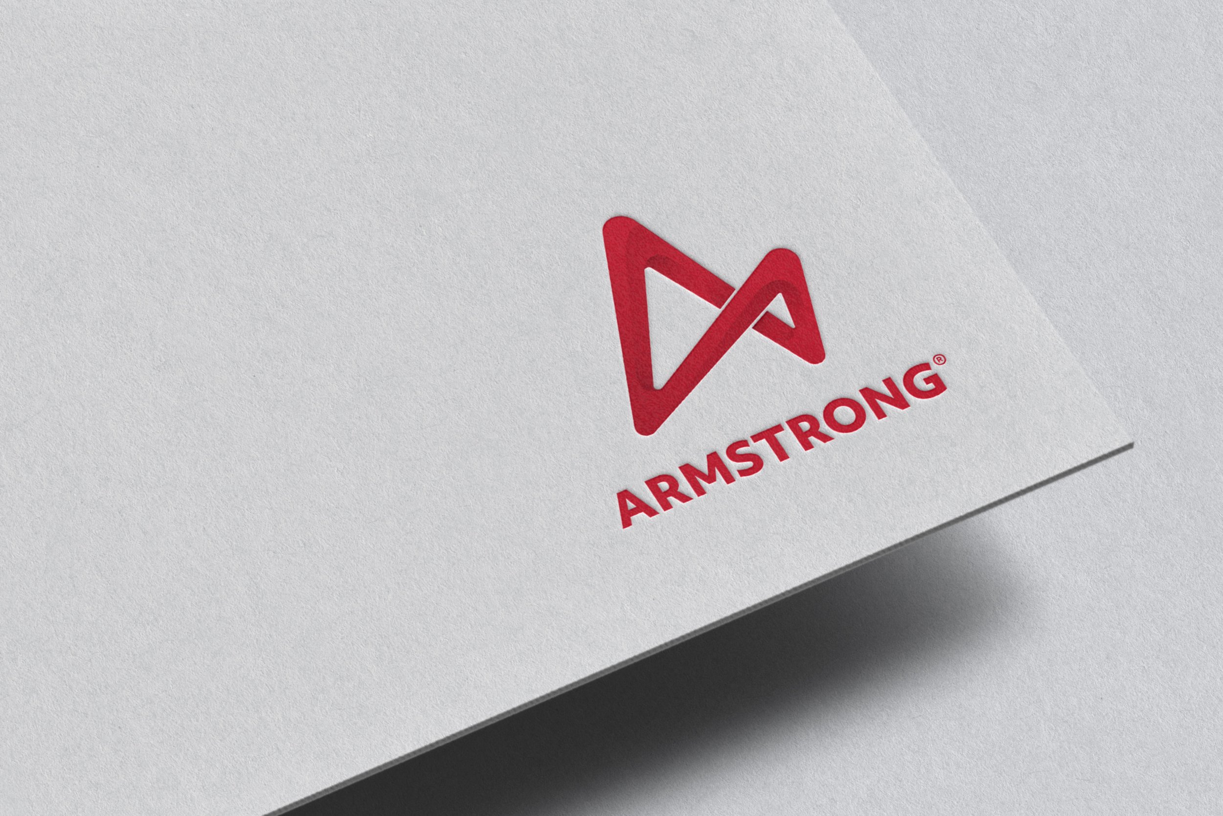 Close-up of a white paper with a red logo and the text 'ARMSTRONG' underneath.
