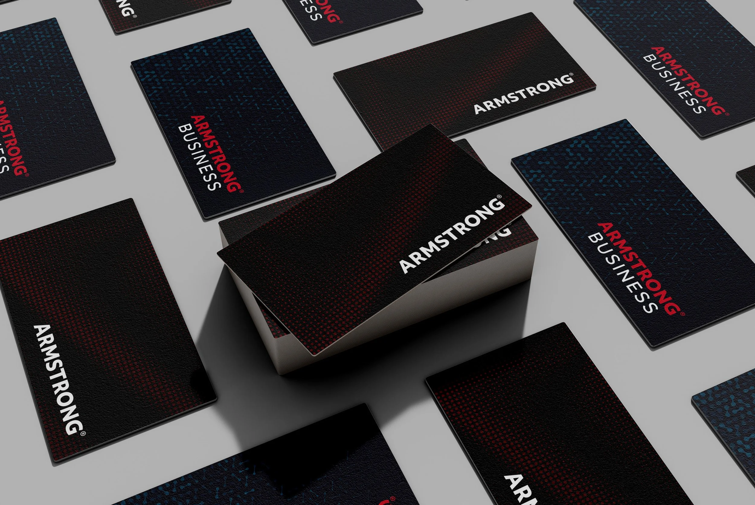 Business cards with black backgrounds, red and white text, and a textured design, all featuring the word "ARMSTRONG" and some cards with the phrase "ARMSTRONG BUSINESS".