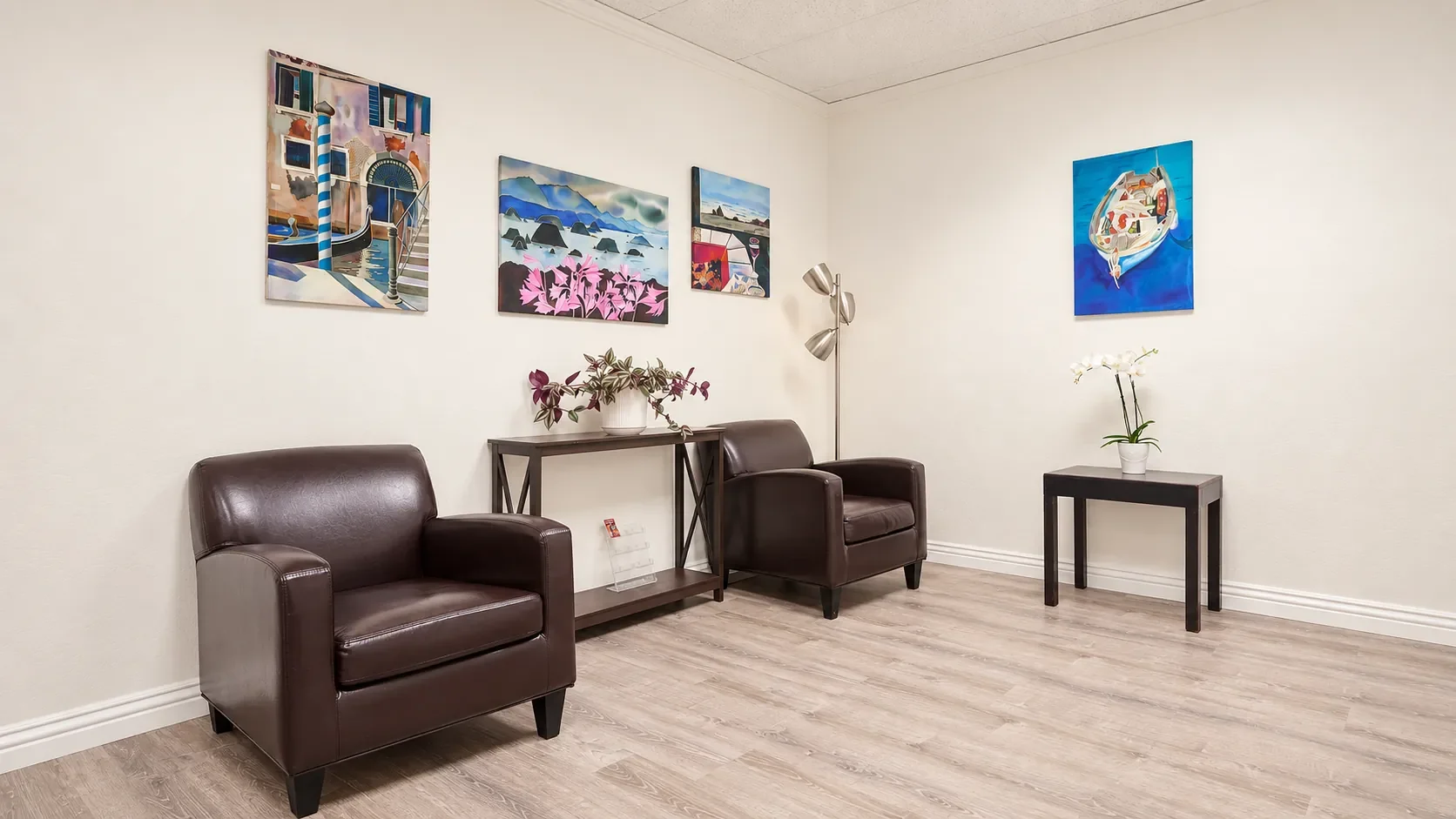 Waiting area at SoRay Hyperbarics with two armchairs, artwork, and a side table.