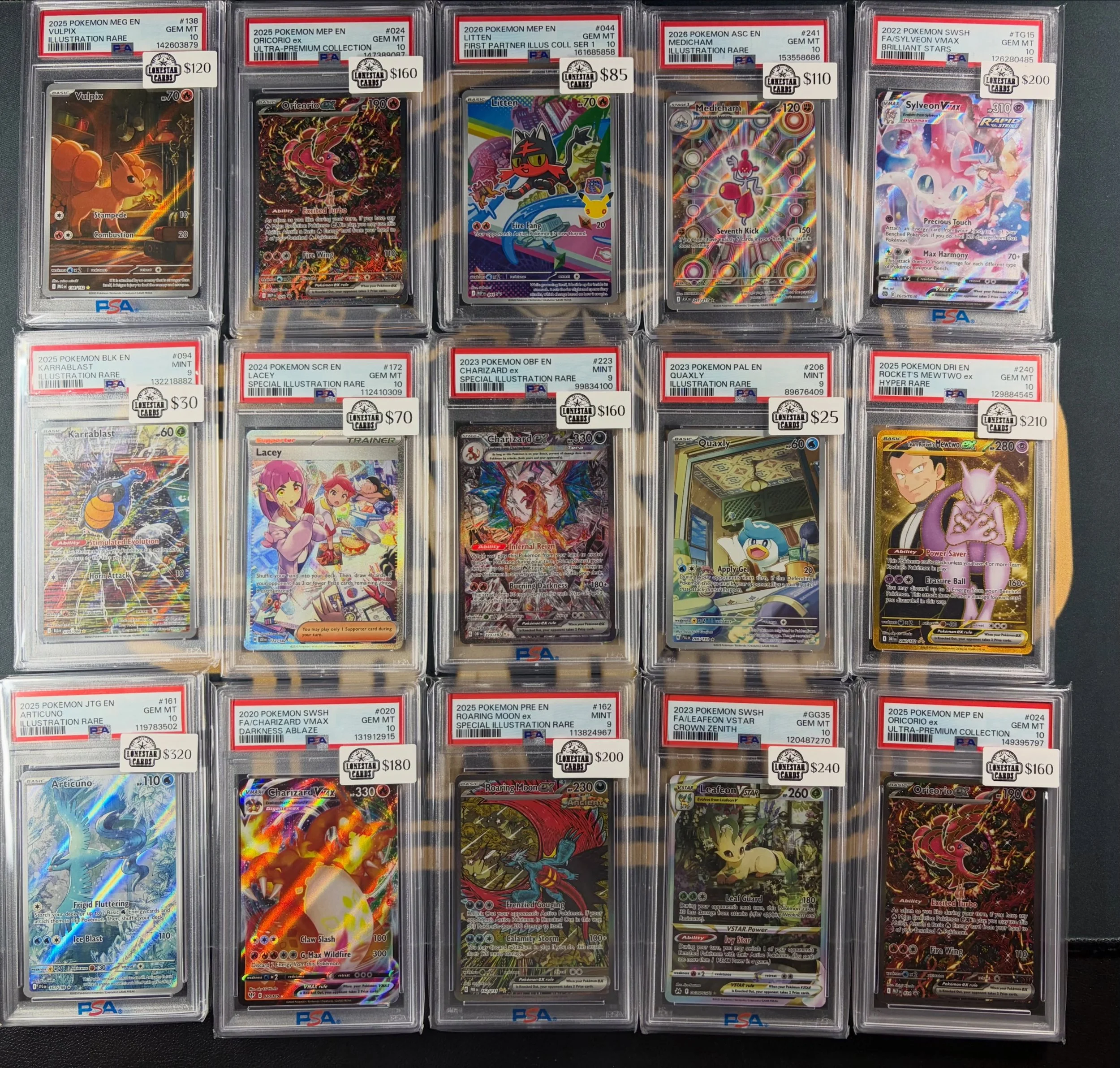 Collection of Pokémon trading cards in protective cases, arranged in rows, with some cards featuring holographic designs and various Pokémon characters.