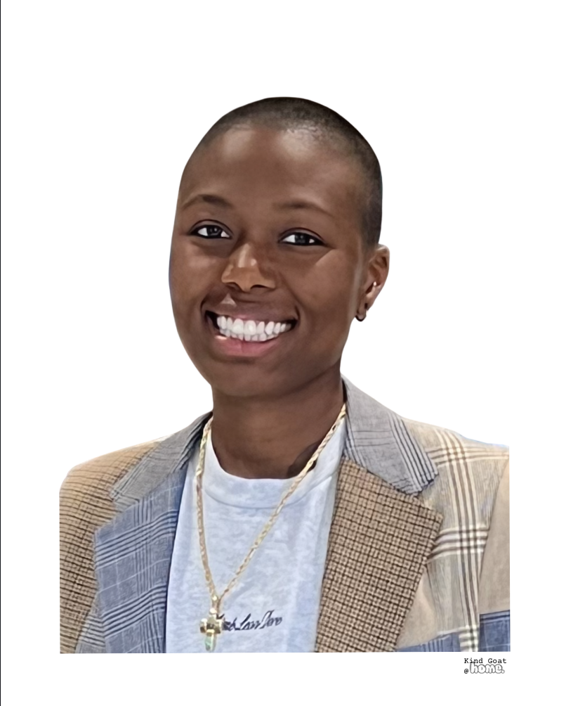 Portrait of a smiling Black woman with a close-cropped haircut, wearing a plaid blazer, a white T-shirt, a gold necklace, and small earrings, against a plain white background.