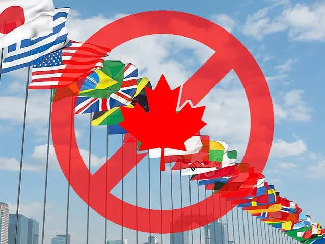 A red prohibition symbol over a Canadian maple leaf and a row of international flags representing Canada's foreign buyer ban on real estate.
