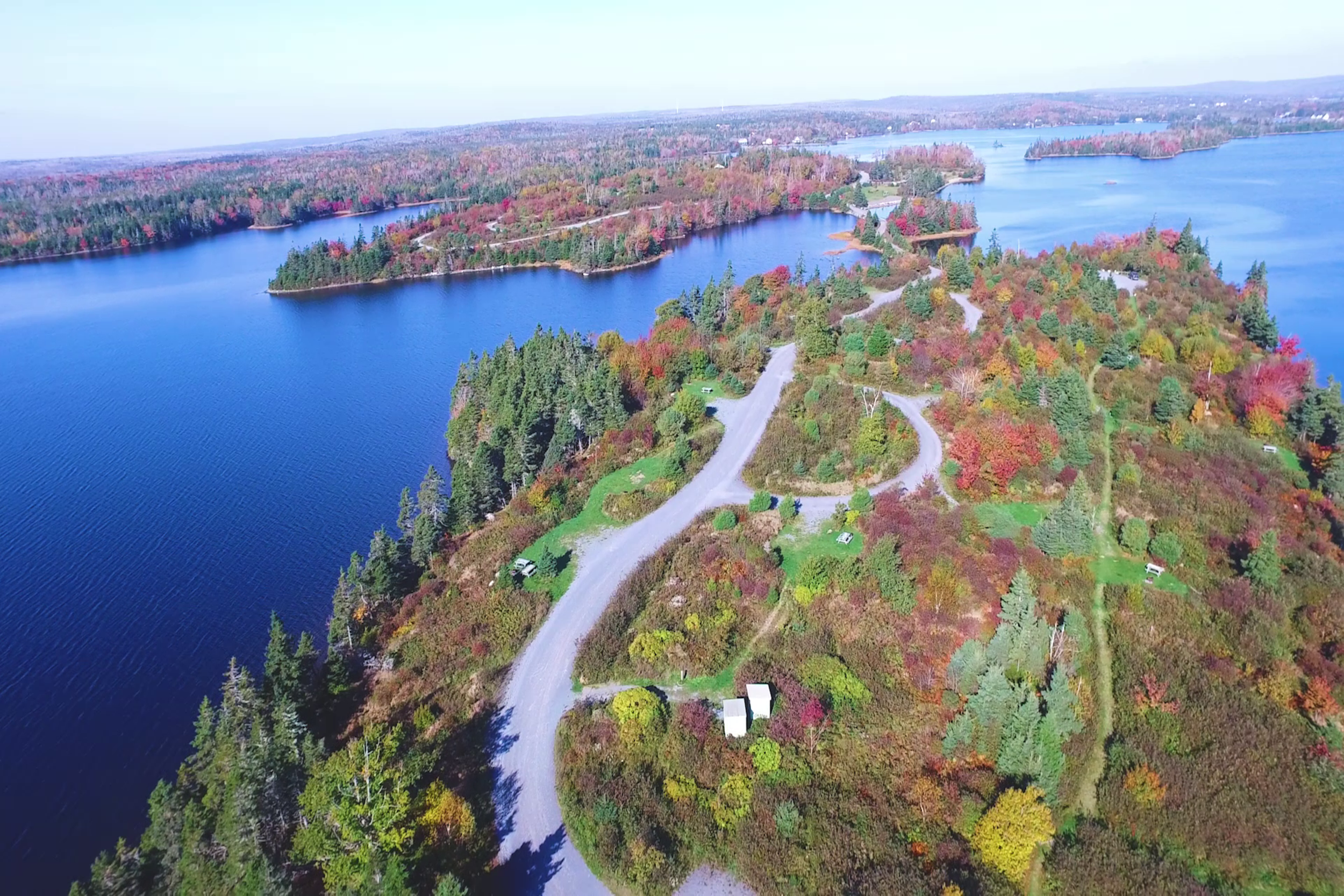 Aerial view of Porters Lake Provincial Park showing winding roads and vibrant autumn foliage along the blue water.