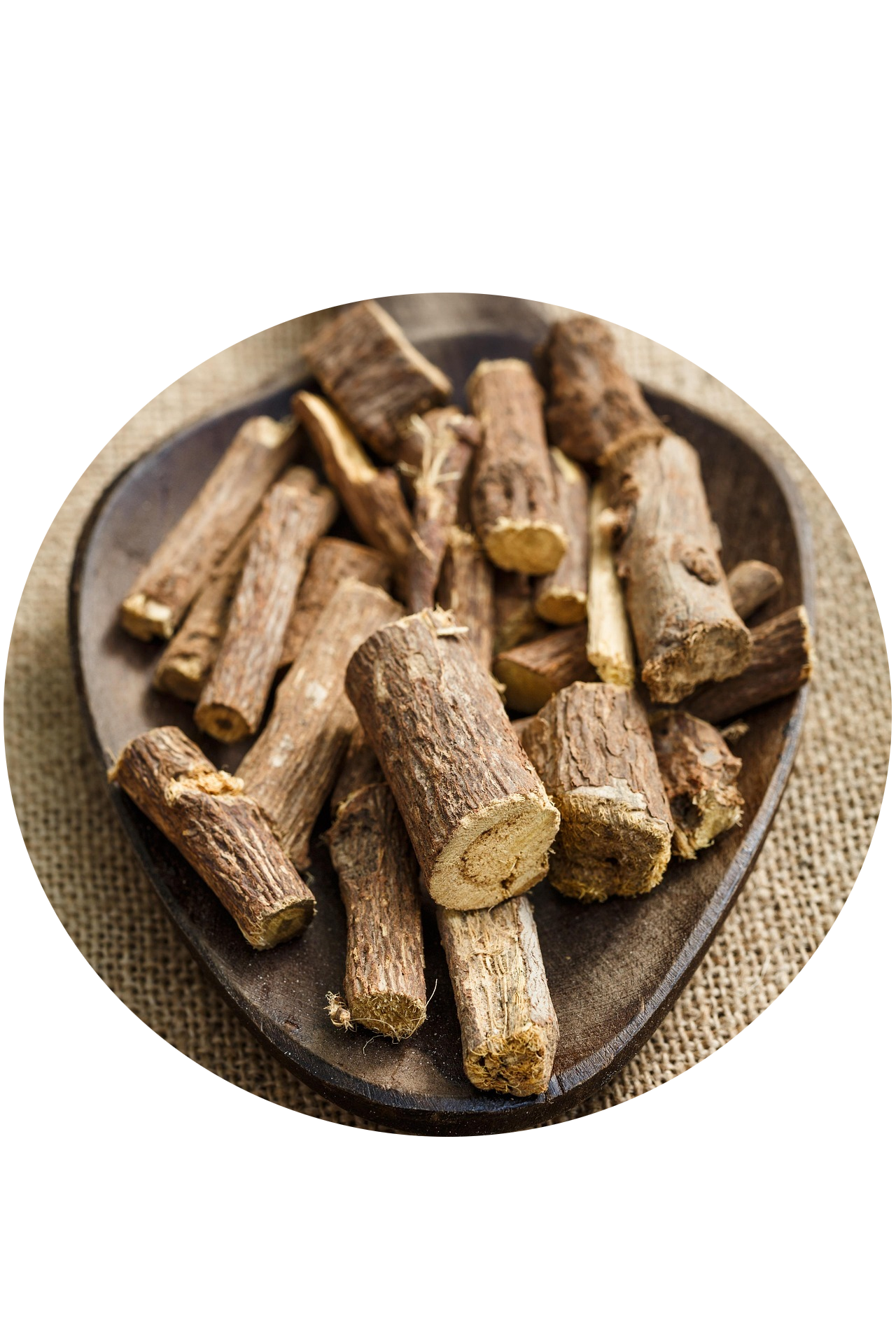 Dried wood logs arranged on a black oval-shaped wooden tray placed on a textured beige surface.