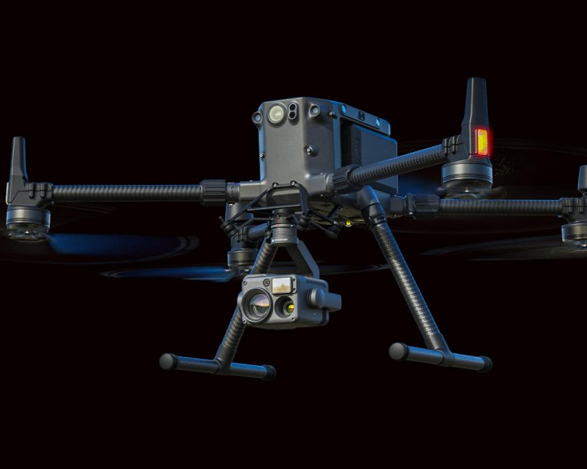 Close-up of a professional drone equipped with cameras and sensors against a black background.