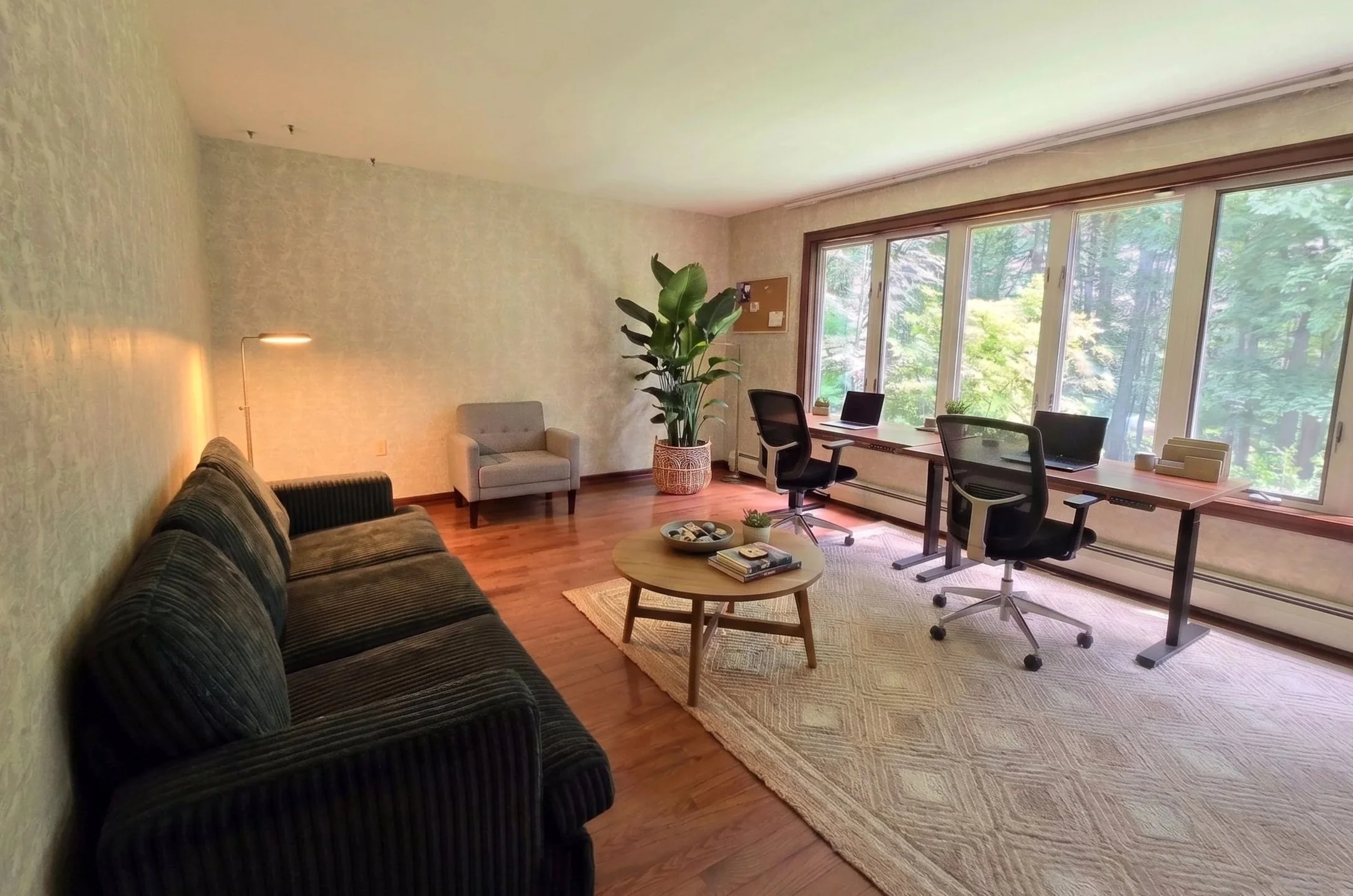 Welcoming entry lobby and visitor office with comfortable couch, wooden coffee table, and window desks at New Soil Sober Living in Northeast Pennsylvania