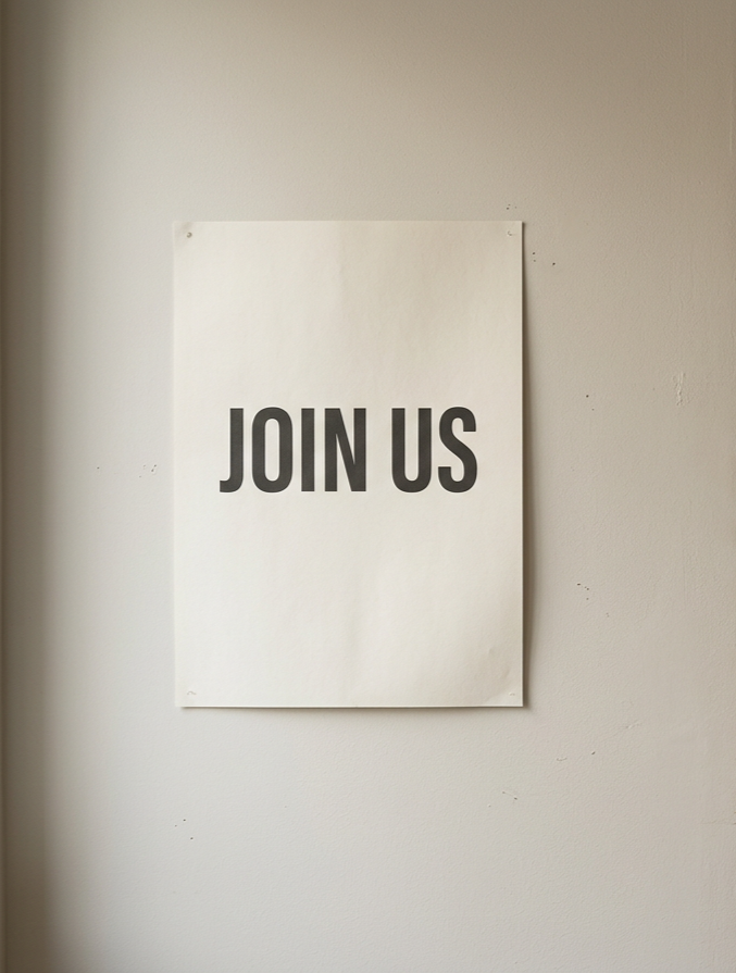 Poster on a wall with the words 'JOIN US' in bold black letters.