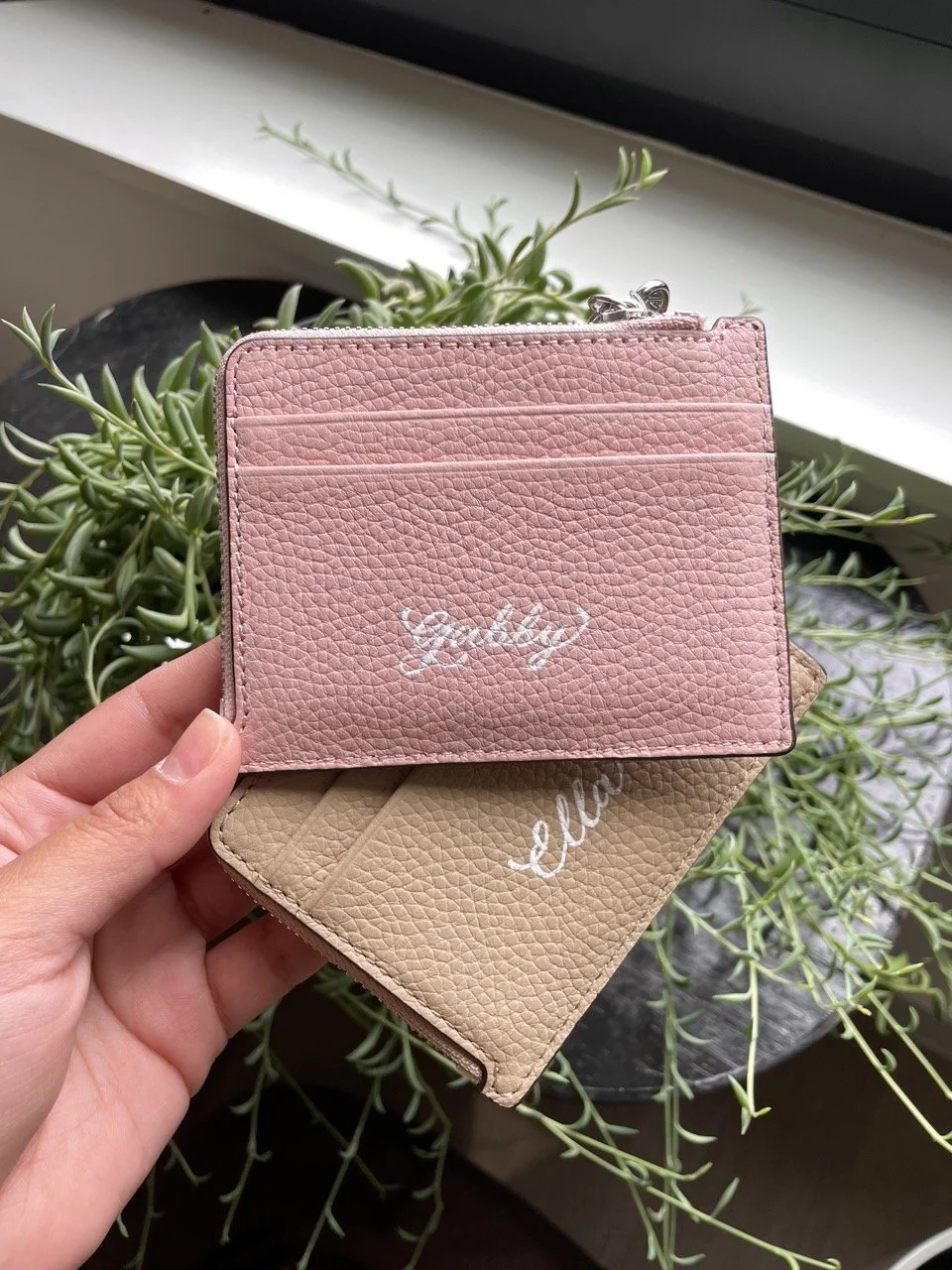 Pink and tan Michael Kors leather wallets personalized with hand painted names in white calligraphy