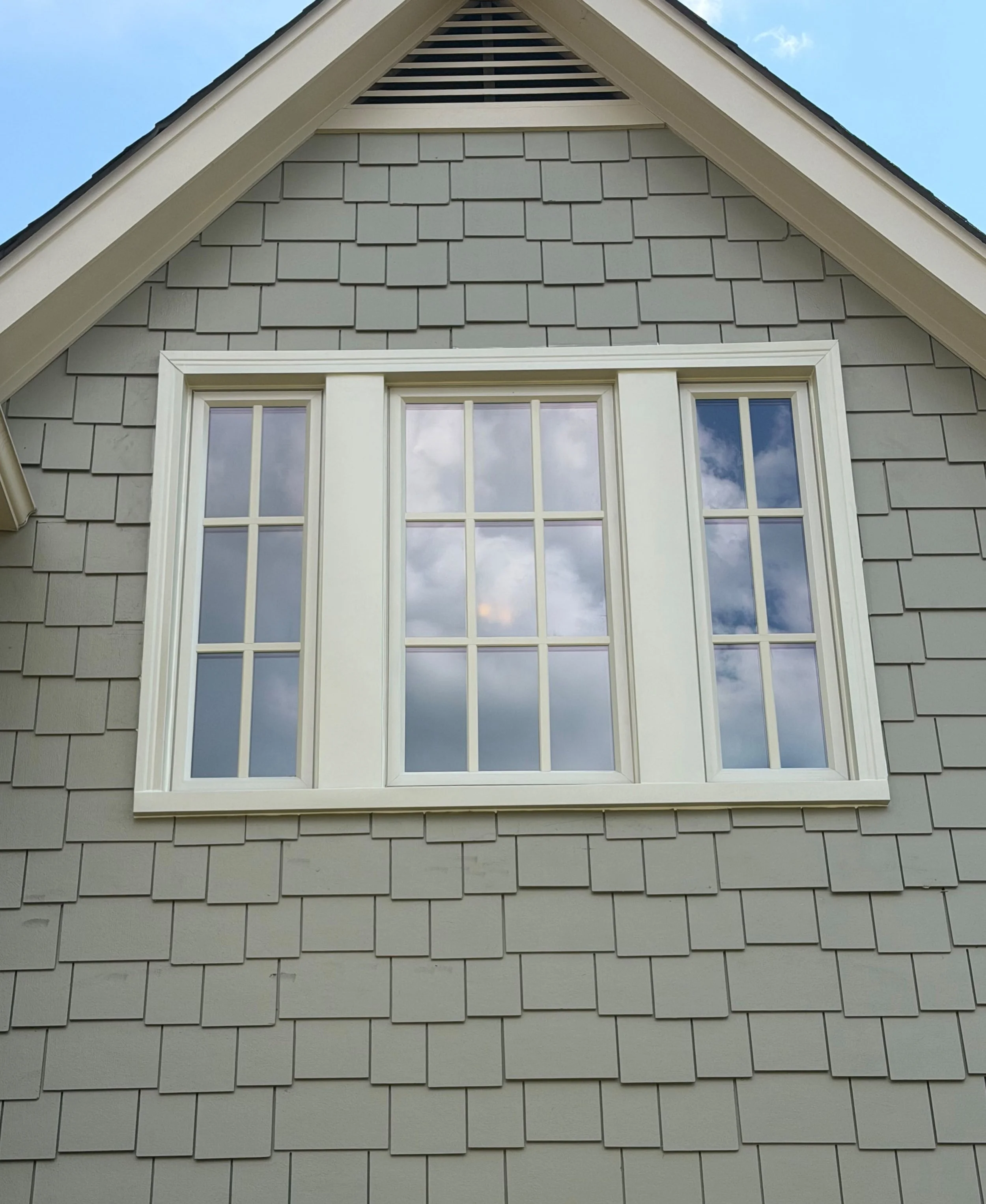 Two-story home with black shutters and replacement windows