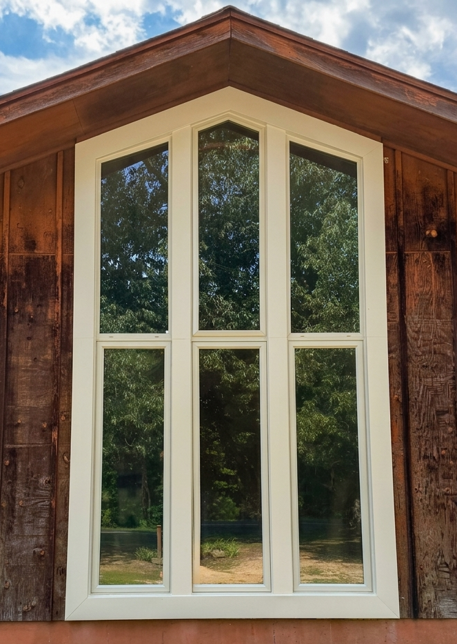 Tall custom window installation in a dark wood-clad exterior