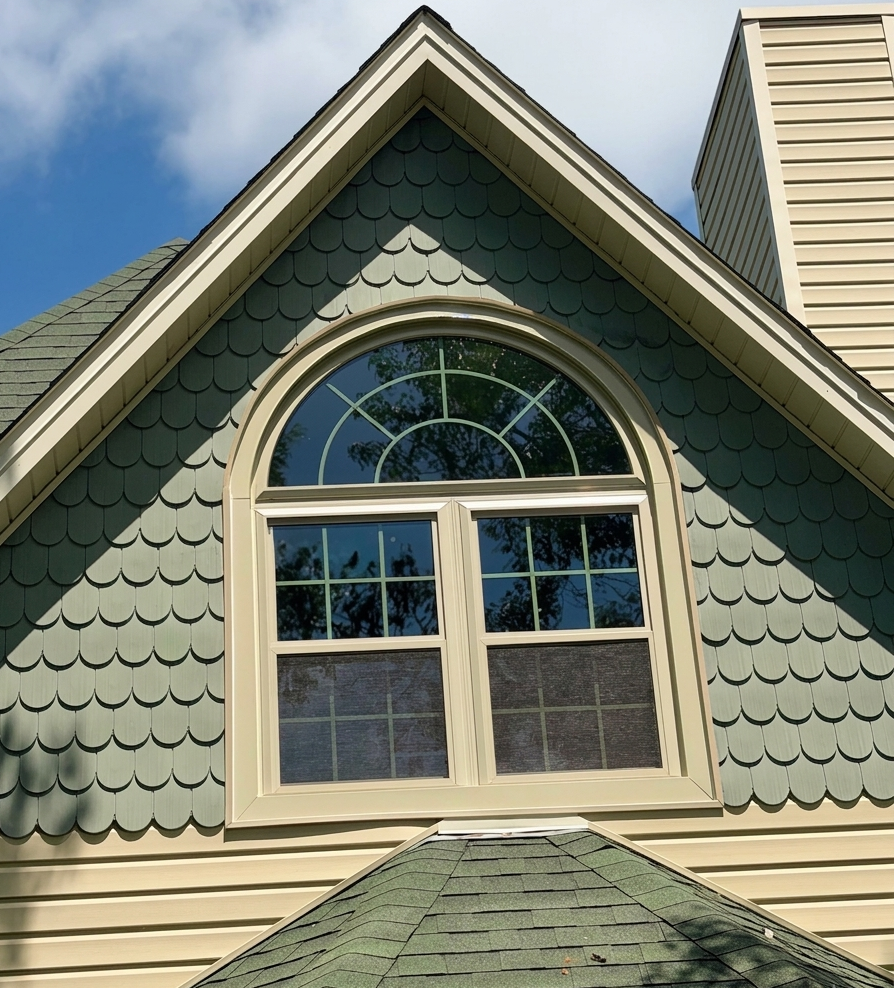 Arched window installed beneath a green scalloped gable