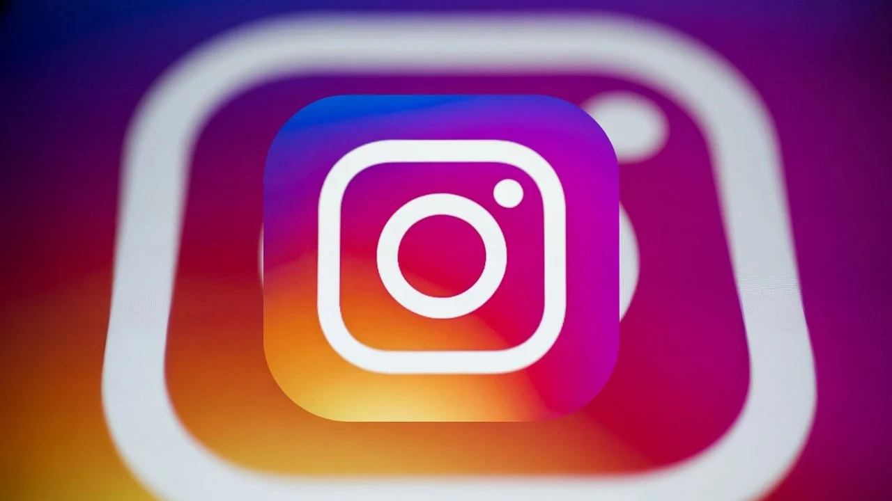 Close-up of the Instagram app icon on a screen with a colorful background.