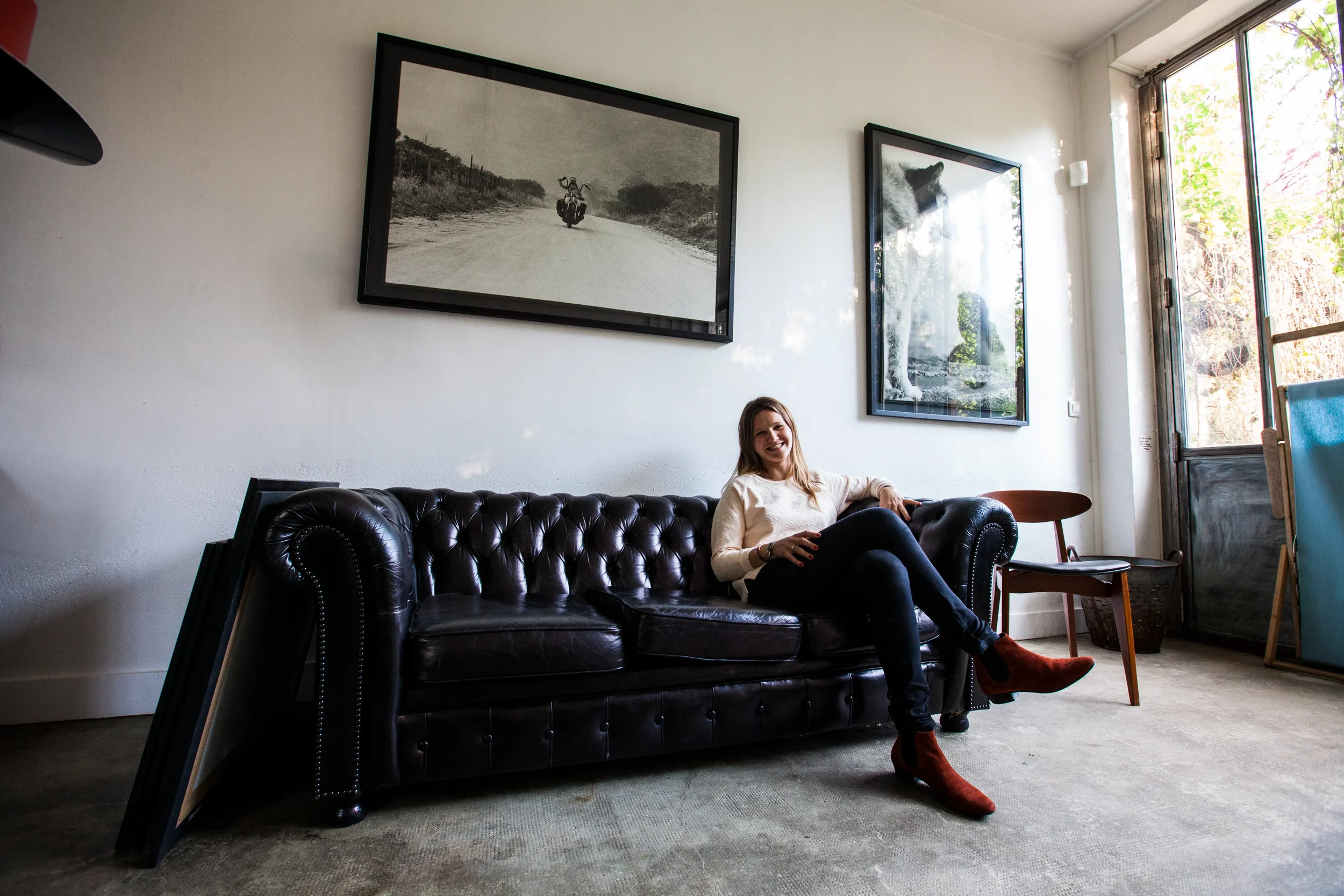 Delphine Martin-Michaud, fondatrice de DMM Interiors, assise sur un canapé Chesterfield dans le projet Maison de Ville Vincennes.