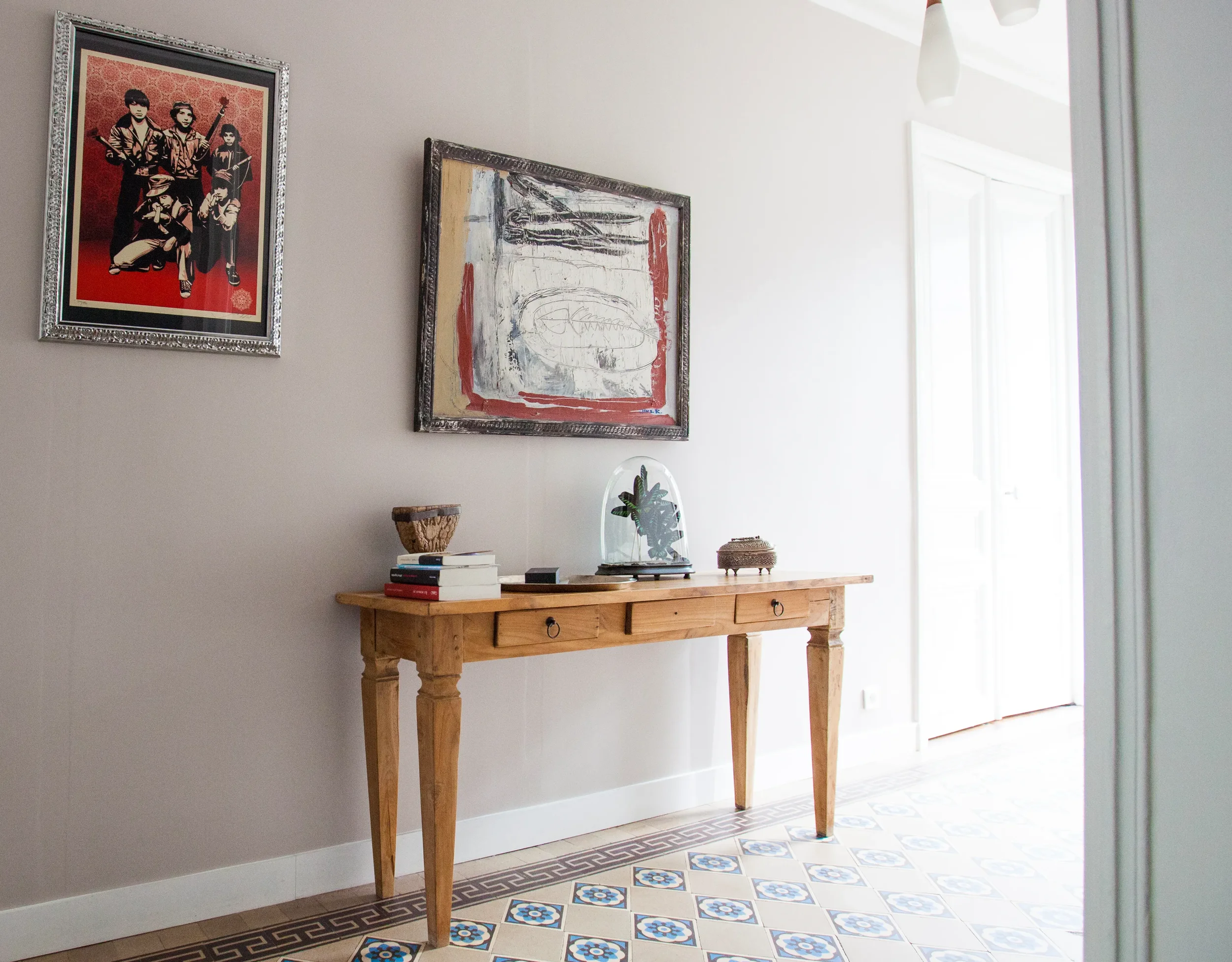 Entrée d'appartement avec console en bois, sol en carreaux de ciment et tableau contemporain, projet Cantona par DMM Interiors.