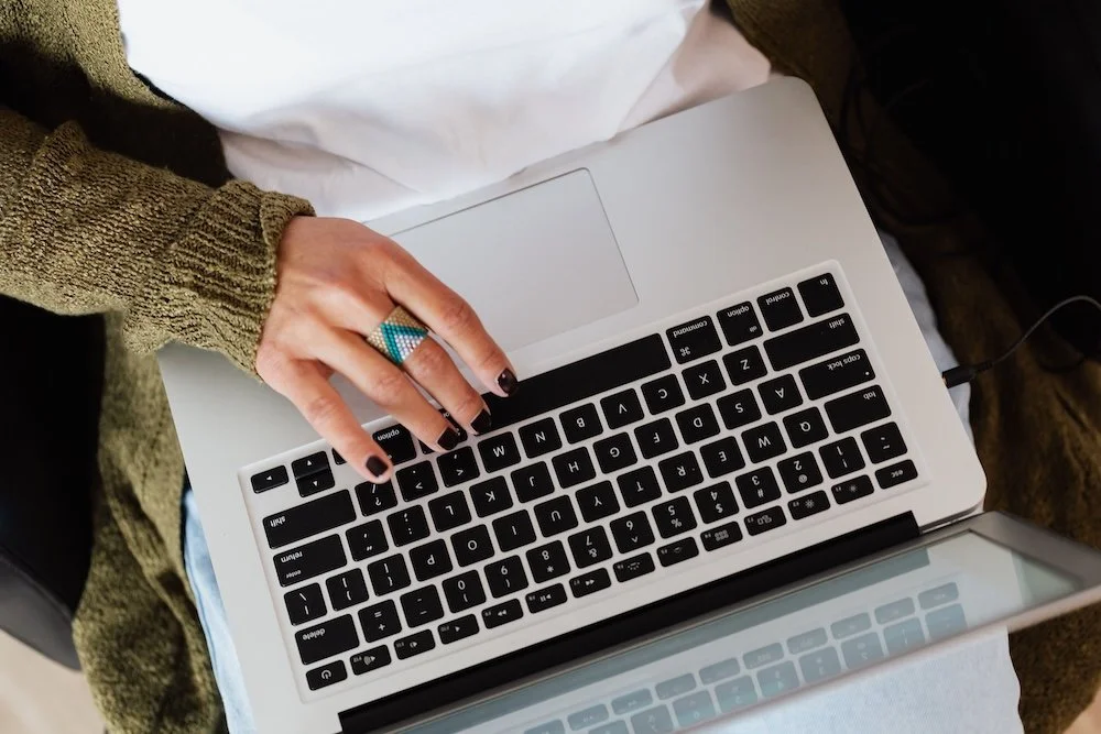 Woman typing on an open laptop