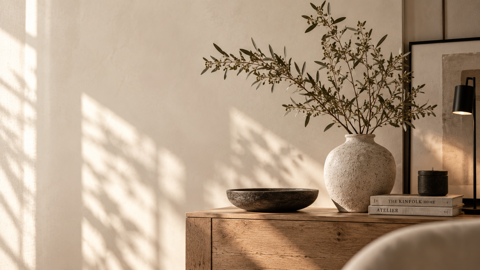 Warme Interior-Szene mit Holzkommode, Keramikvase, Zweigen und natürlichen Beige- und Brauntönen.
