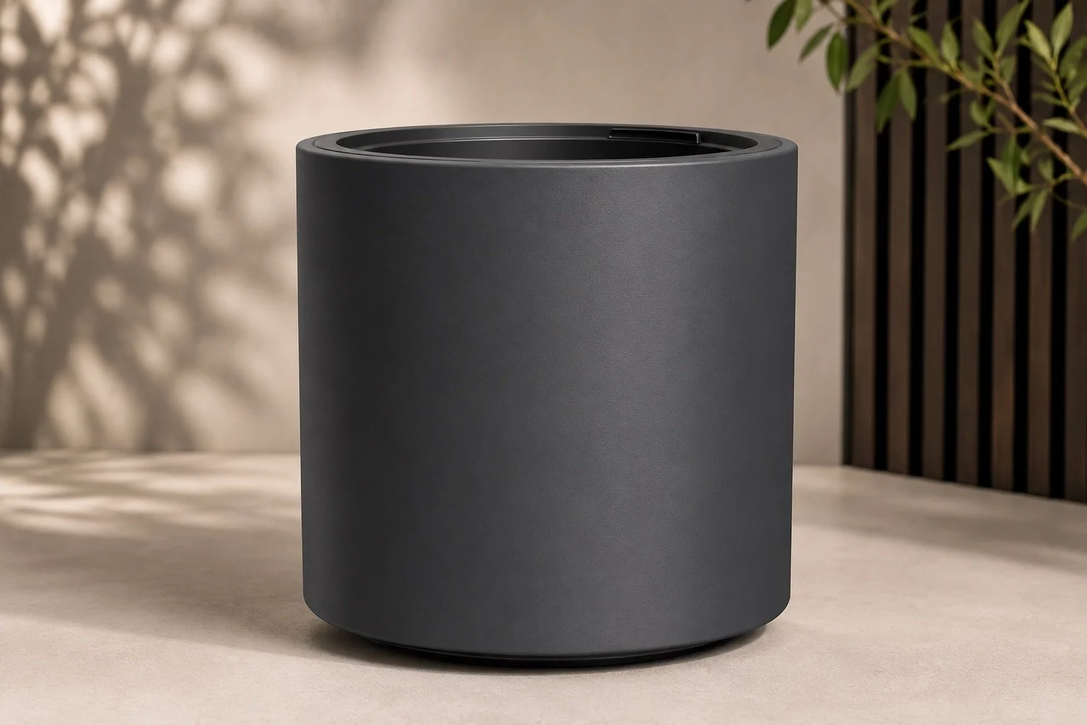Moderner Pflanzkübel in Anthrazit für eine minimalistische Terrassengestaltung mit schwarzen Akzenten und natürlichem Grün.