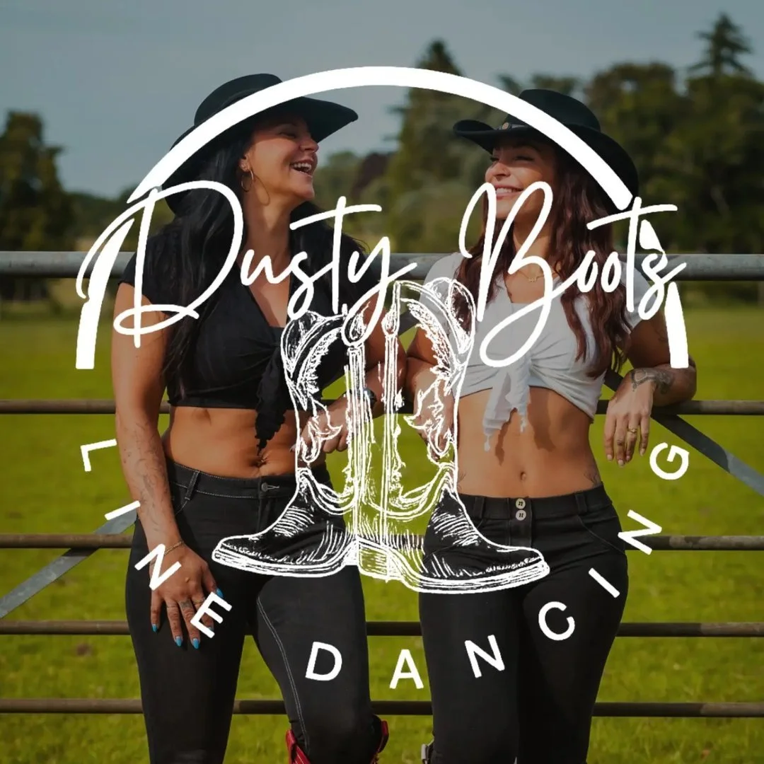 Two women wearing cowboy hats and black pants outdoors, smiling and laughing. Overlaid text reads 'Dusty Boots Line Dancing' with a graphic of cowboy boots and a circular design.