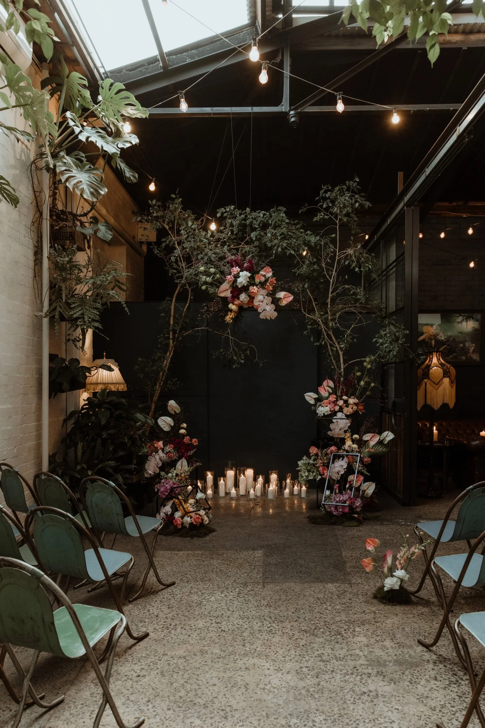 Indoor floral setup with candles and string lights, decorated for a wedding or event at Rupert on Rupert.