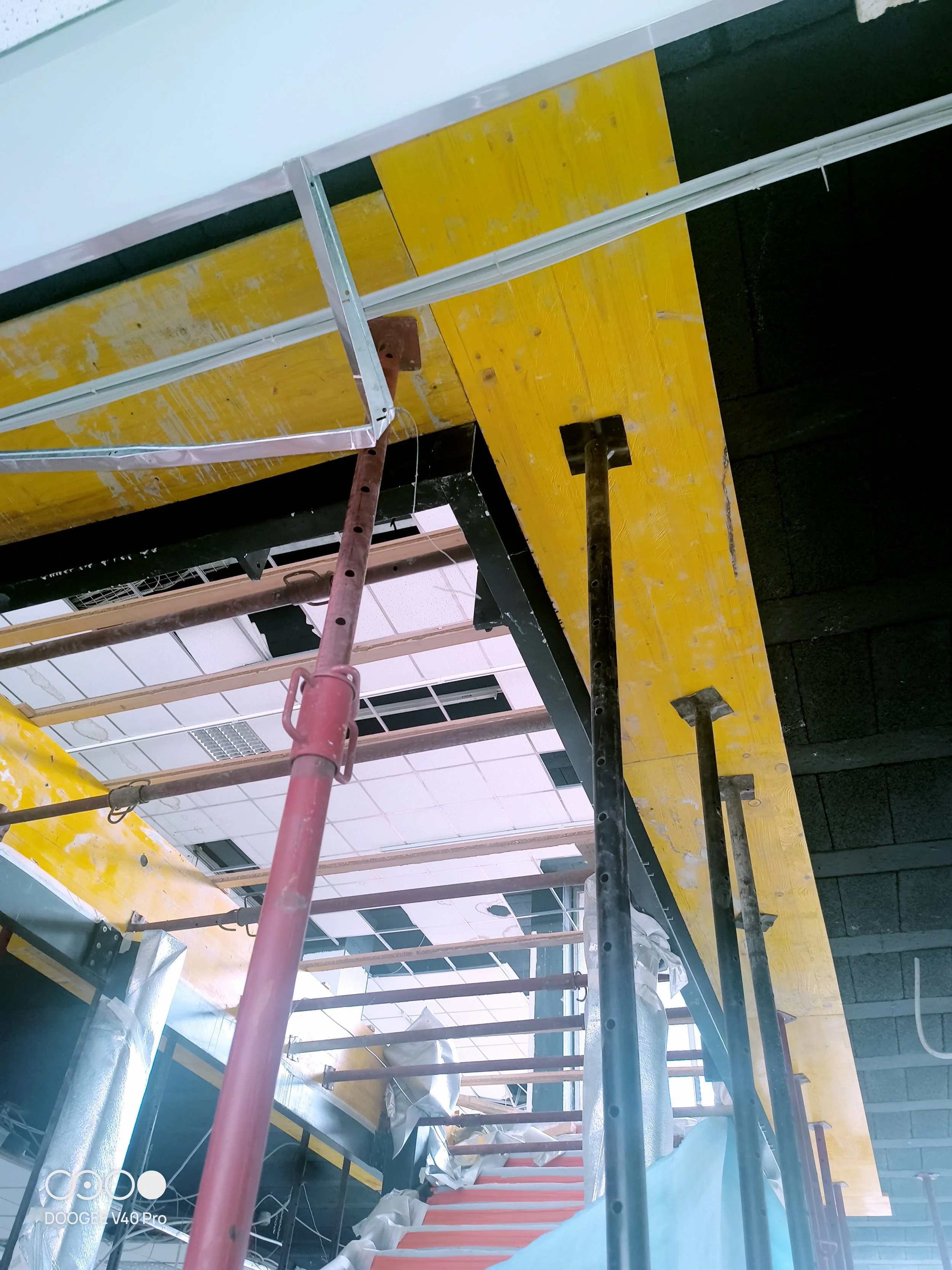 Immagine di un cantiere con ponteggio e materiali da costruzione, muri in fase di finitura.