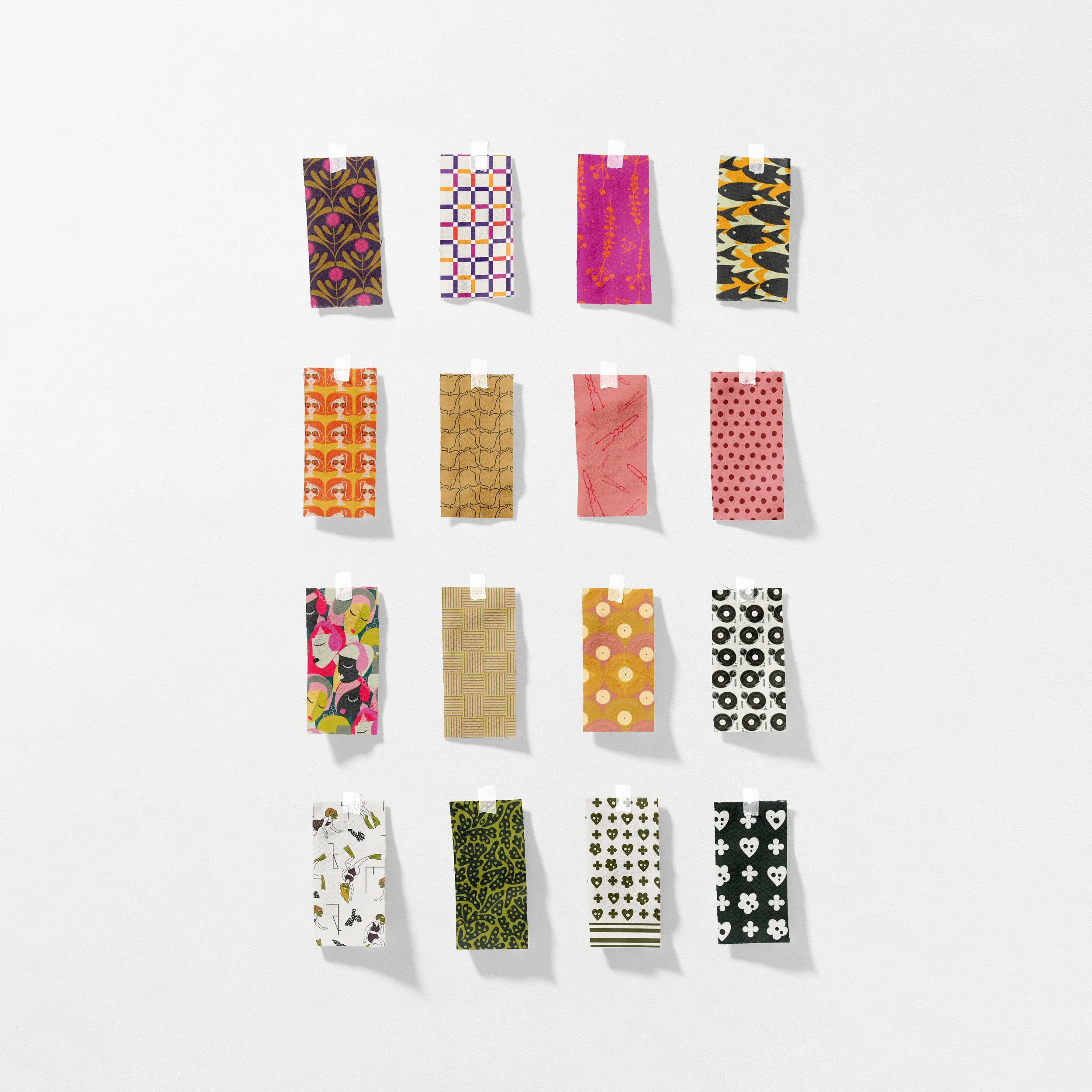 Colorful strips of fabric with various patterns taped to a white wall.