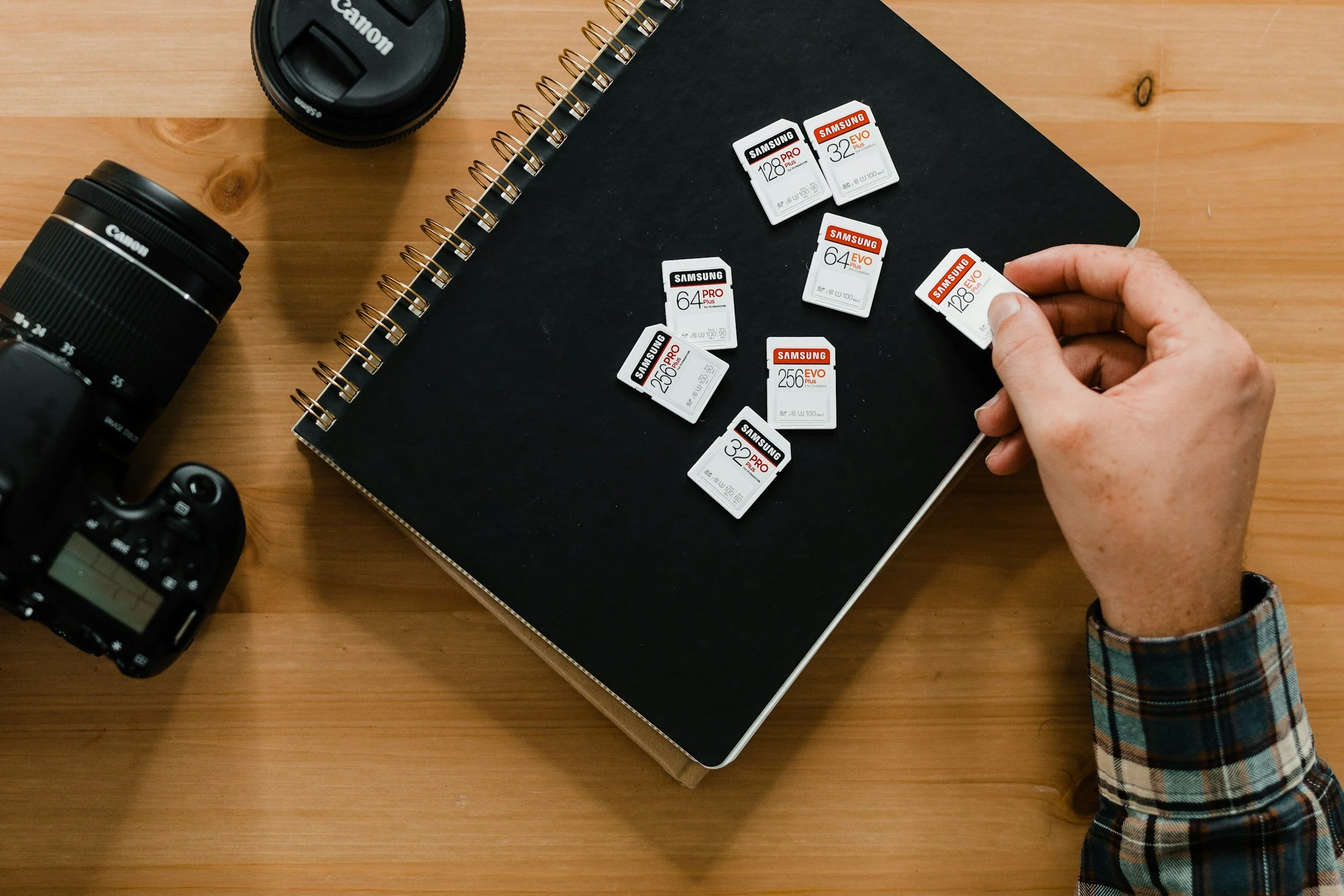 Camera gear and SD cards on workspace representing Florida photographer expense tracking