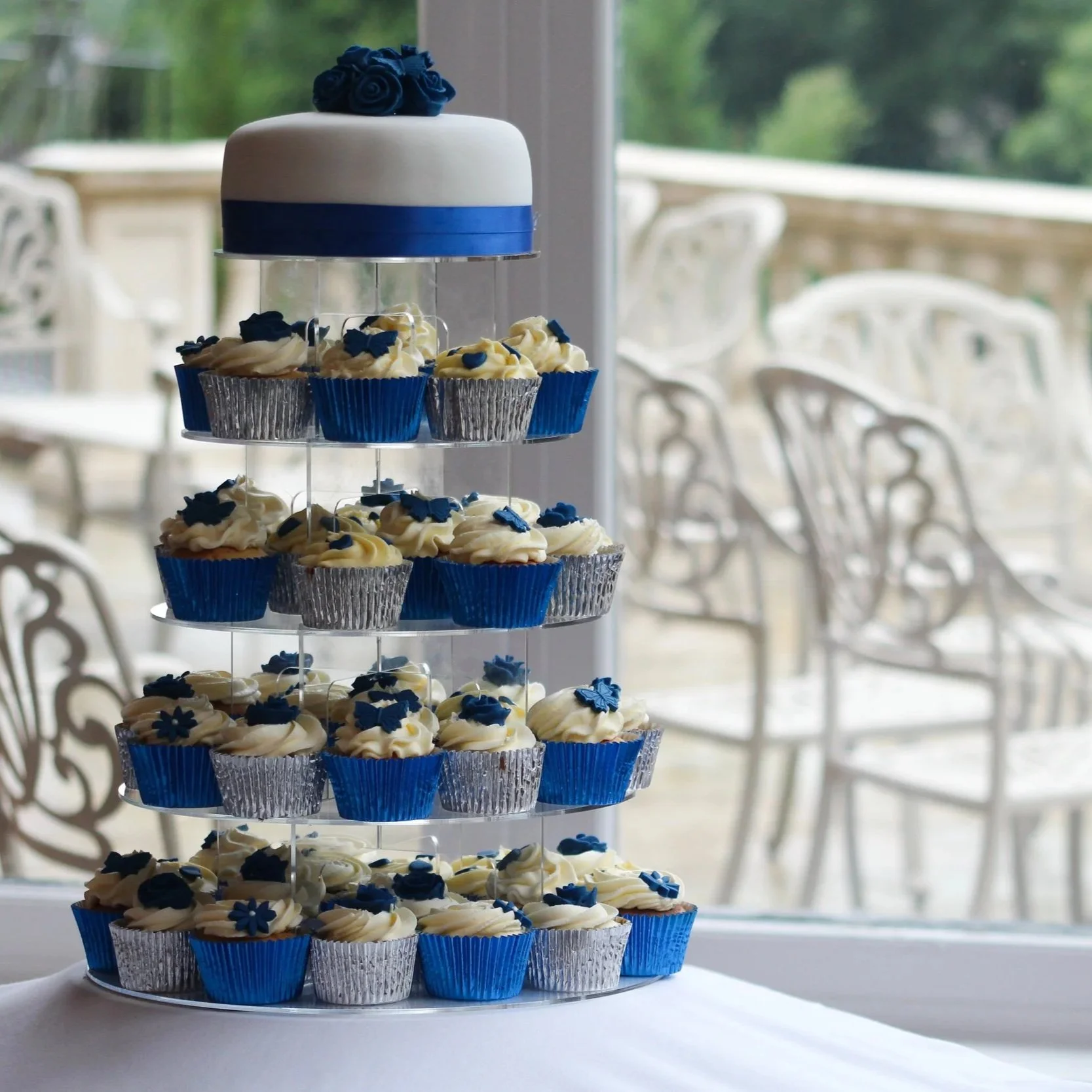 Eventfotografie van een blauwe en witte taart met cupcakes op een feestlocatie.