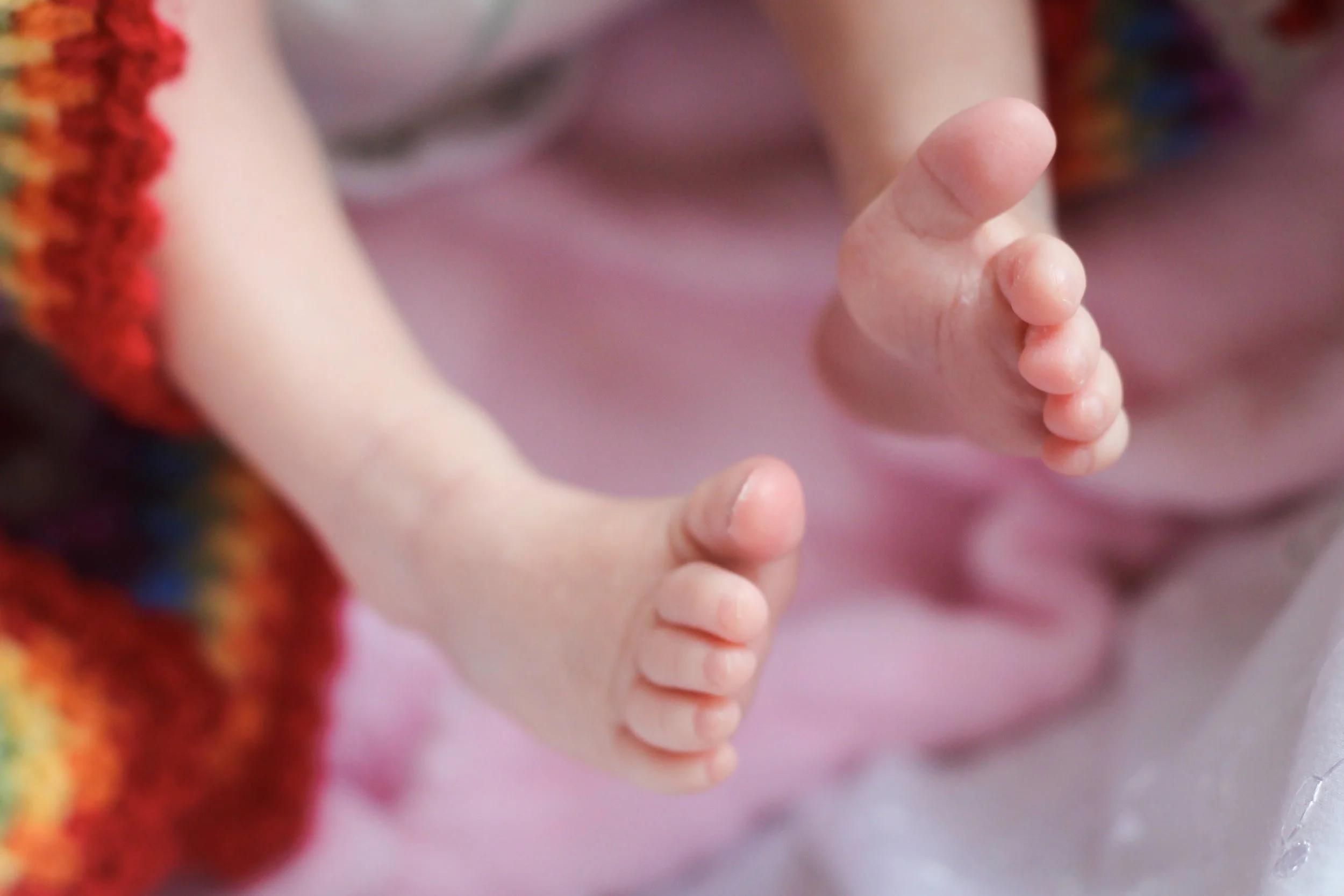 Close-up van een kind dat met open hand de hand van een andere persoon vasthoudt.