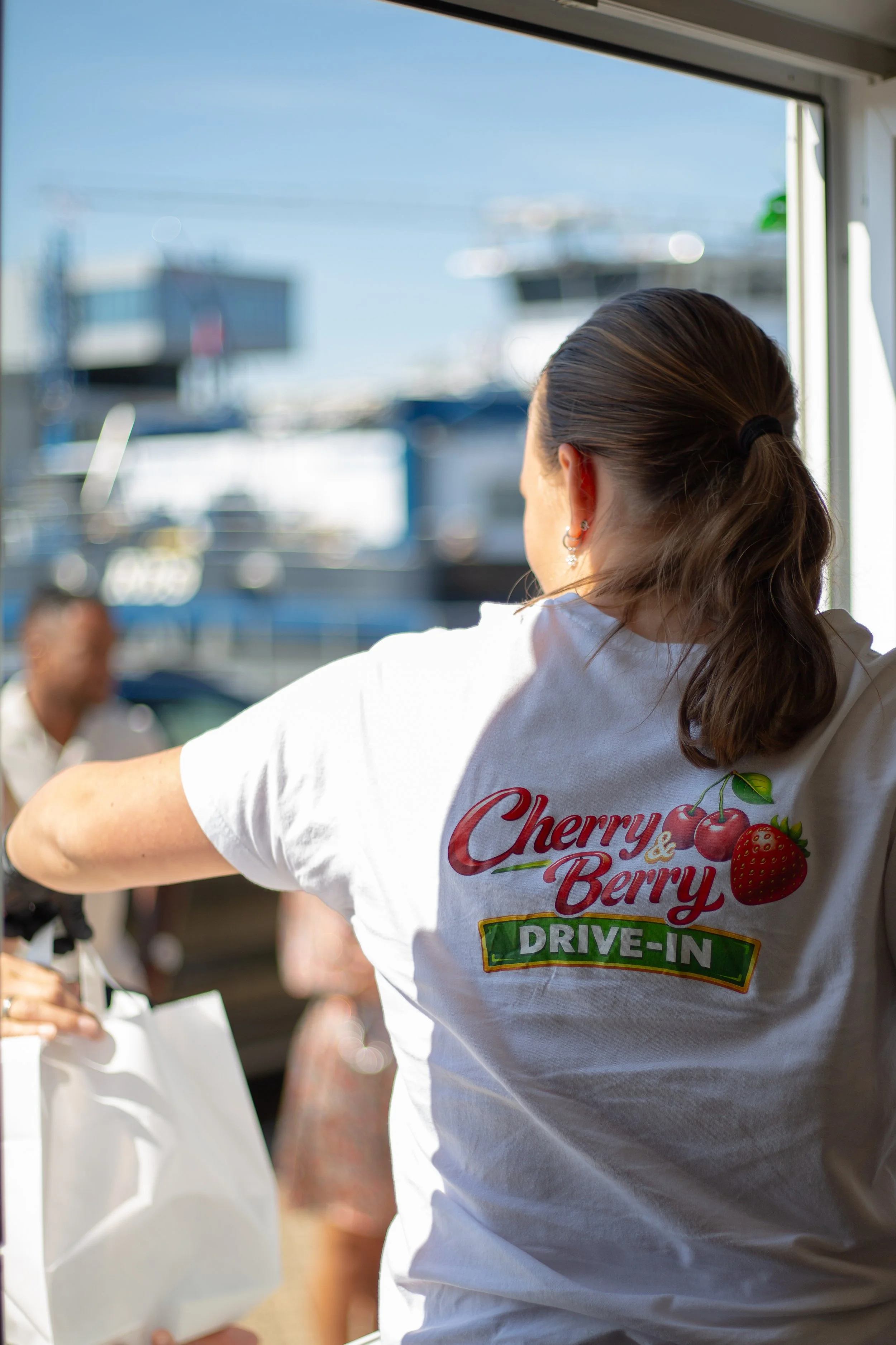 Bedrijfsfotografie van een medewerker die bestellingen serveert bij Cherry & Berry Drive-In